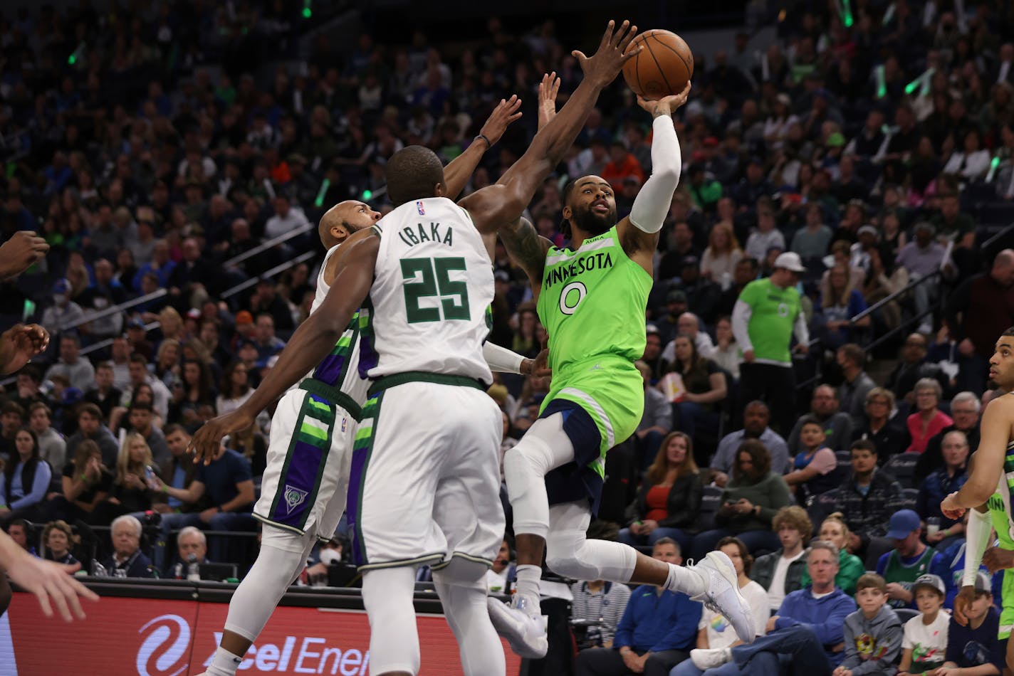 Timberwolves guard D'Angelo Russell shoots against Bucks guard Jevon Carter, left, and center Serge Ibaka (25) during the second half Saturday