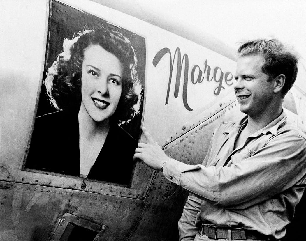 Capt. Richard J. Bong points to a large picture of his girlfriend, Marge Vattendahl, on his P-38 Lightning fighter plane at a New Guinea air base on March 31, 1944. 