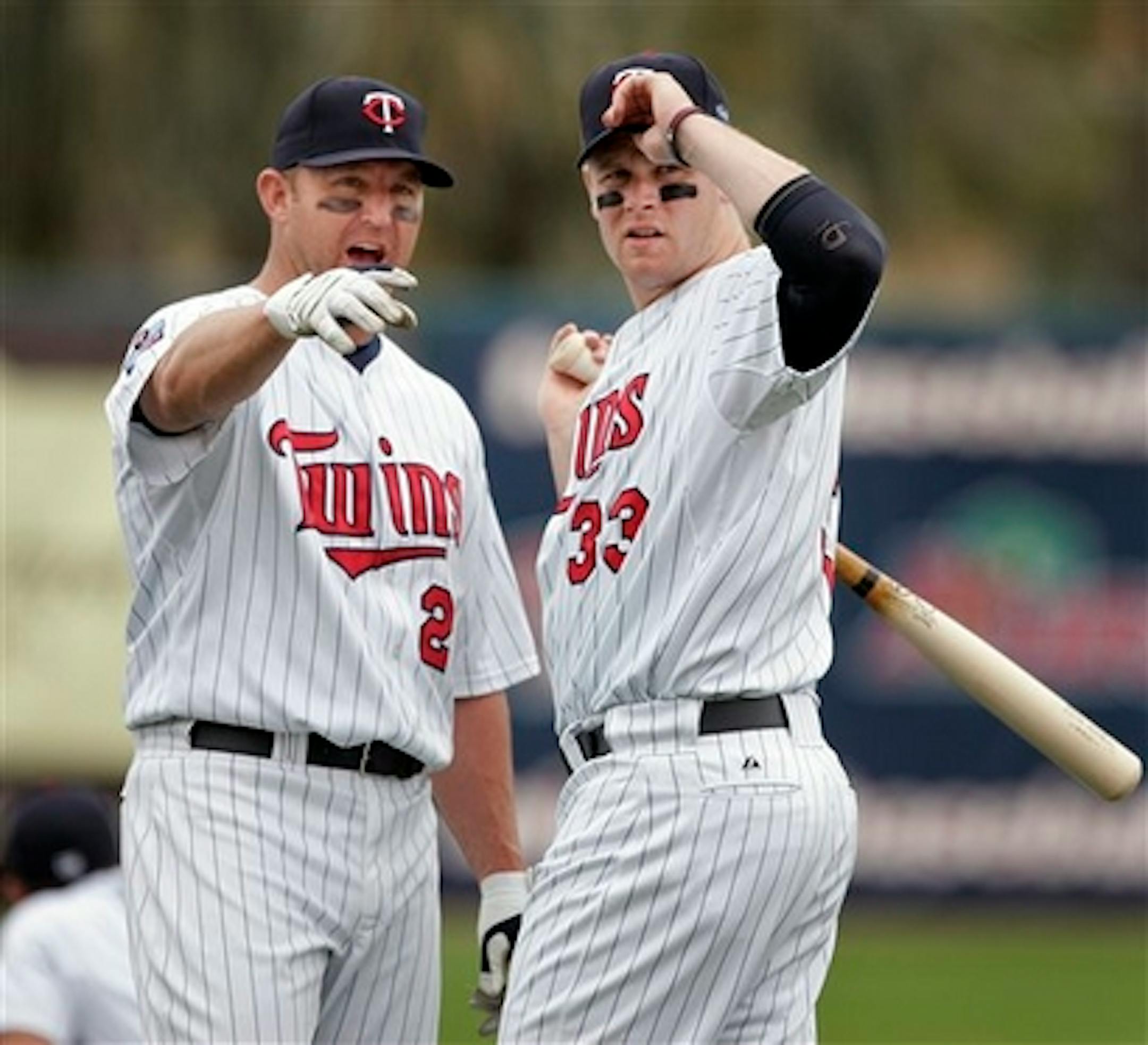 Minnesota Twins designated hitter Jim Thome, left, and first baseman Justin Morneau, right, chat on the field moments before the start of a spring training baseball game against the St. Louis Cardinals, in Fort Myers, Fla., Tuesday, March 9, 2010.  (AP Photo/Steven Senne)