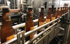 In this Jan. 14, 2019, photo, bottles, freshly filled with beer, move on a belt at Lakefront Brewery in Milwaukee. The federal shutdown is impacting t