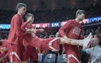 Nebraska bench players carry off a team mate in a skit after a shot was made during the second half of an NCAA college basketball game in Champaign, I
