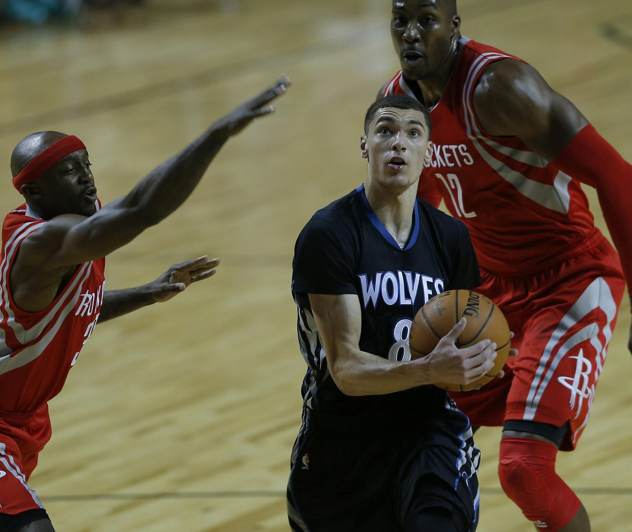 Minnesota Timberwolves' Zack Levine, center (8) runs past Houston Rockets' Dwight Howard, (12), right, and Jason Terry (31) as he prepares to attempt a shot during the first half of an NBA basketball game in Mexico City, Wednesday, Nov. 12, 2014. (AP Photo/Dario Lopez-Mills)