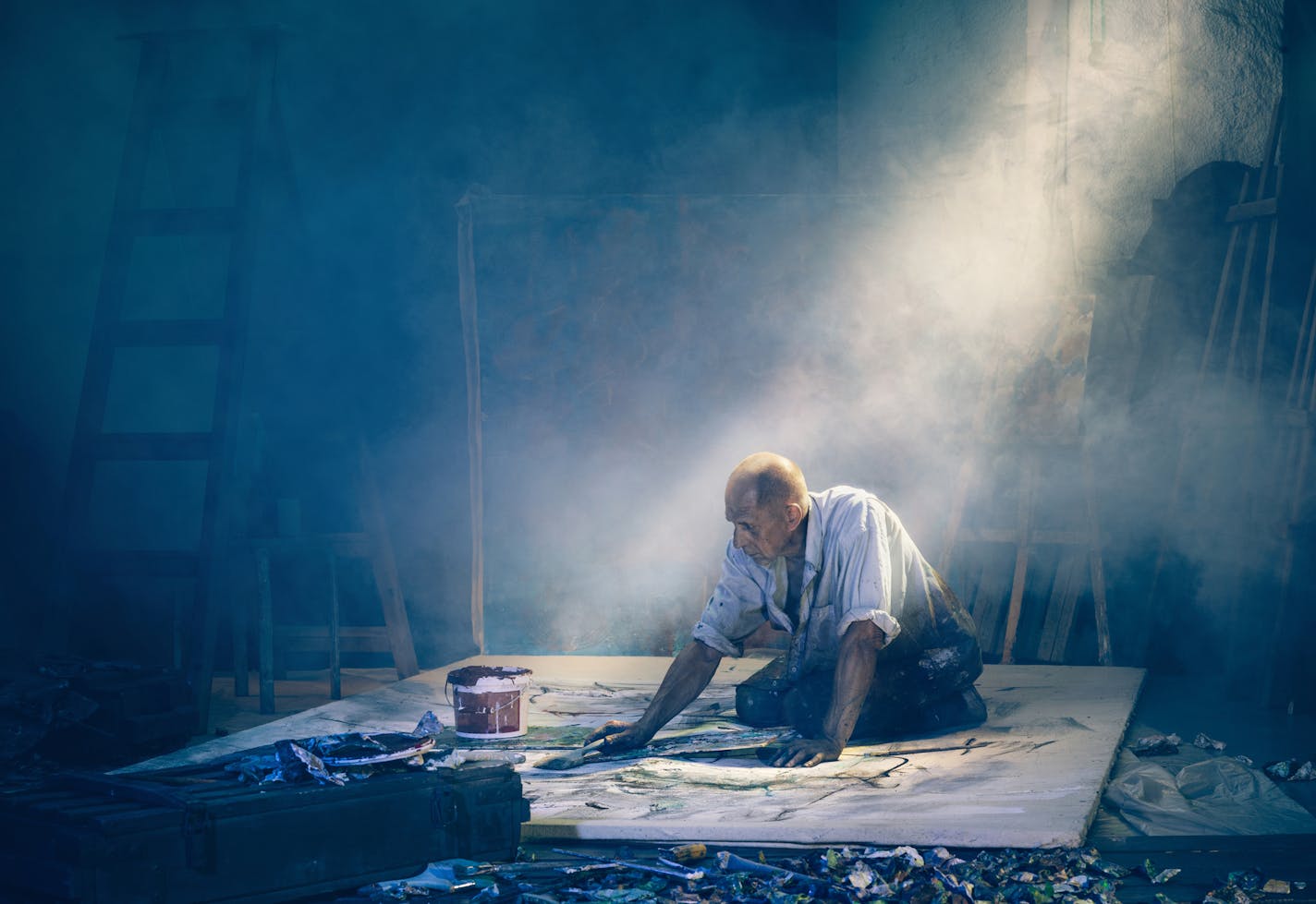 Artist painting picture in workshop rear view. The mature man at studio