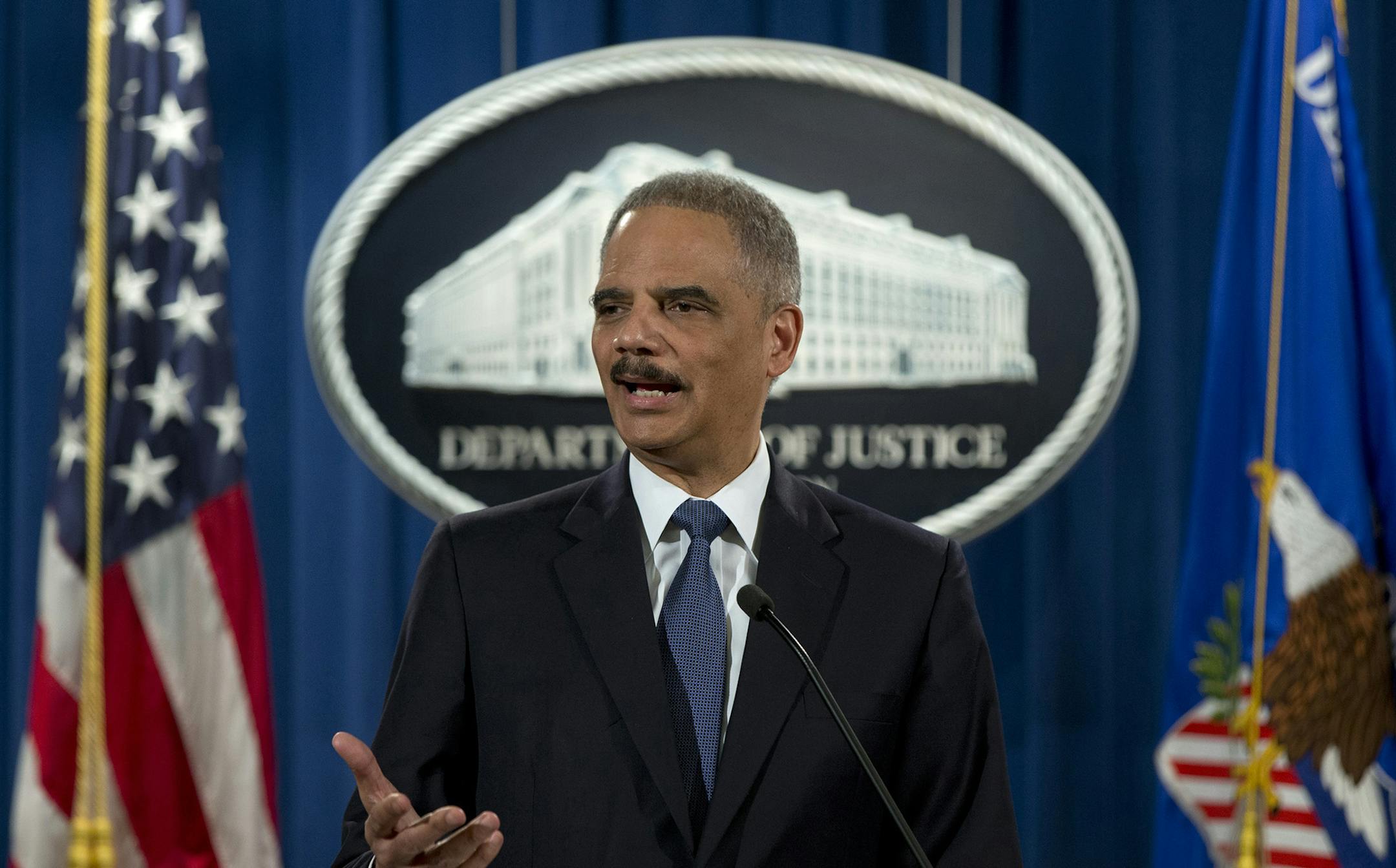 Attorney General Eric Holder speaks at the Justice Department in Washington, Wednesday, March 4, 2015, to discuss the Aug. 9, 2014 shooting in Ferguson, Mo. The Justice Department will not prosecute a white former police officer in the fatal shooting of an unarmed black 18-year-old whose death in Ferguson sparked weeks of protests and ignited an intense national debate over how police treat African-Americans. But the government released a scathing report Wednesday that faulted the city for racia