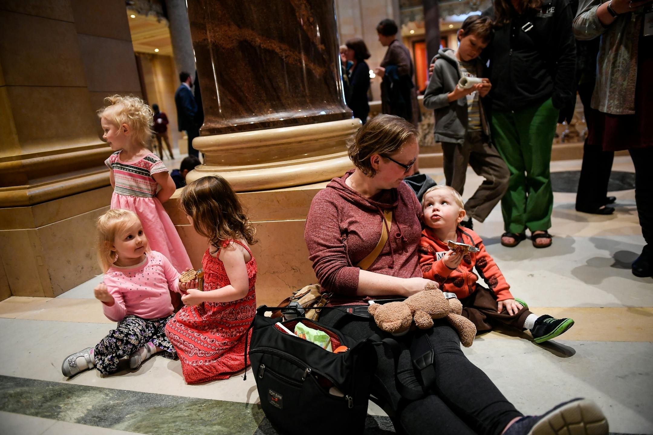 Angela Byrne, with the Minnesota Association of Professional Employees, looked to her son, Henry, 2, as they waited outside the house chambers Tuesday night. Byrne was with a group of state employees who are worried that parental leave could be inserted into a bill that could face a veto by the governor.