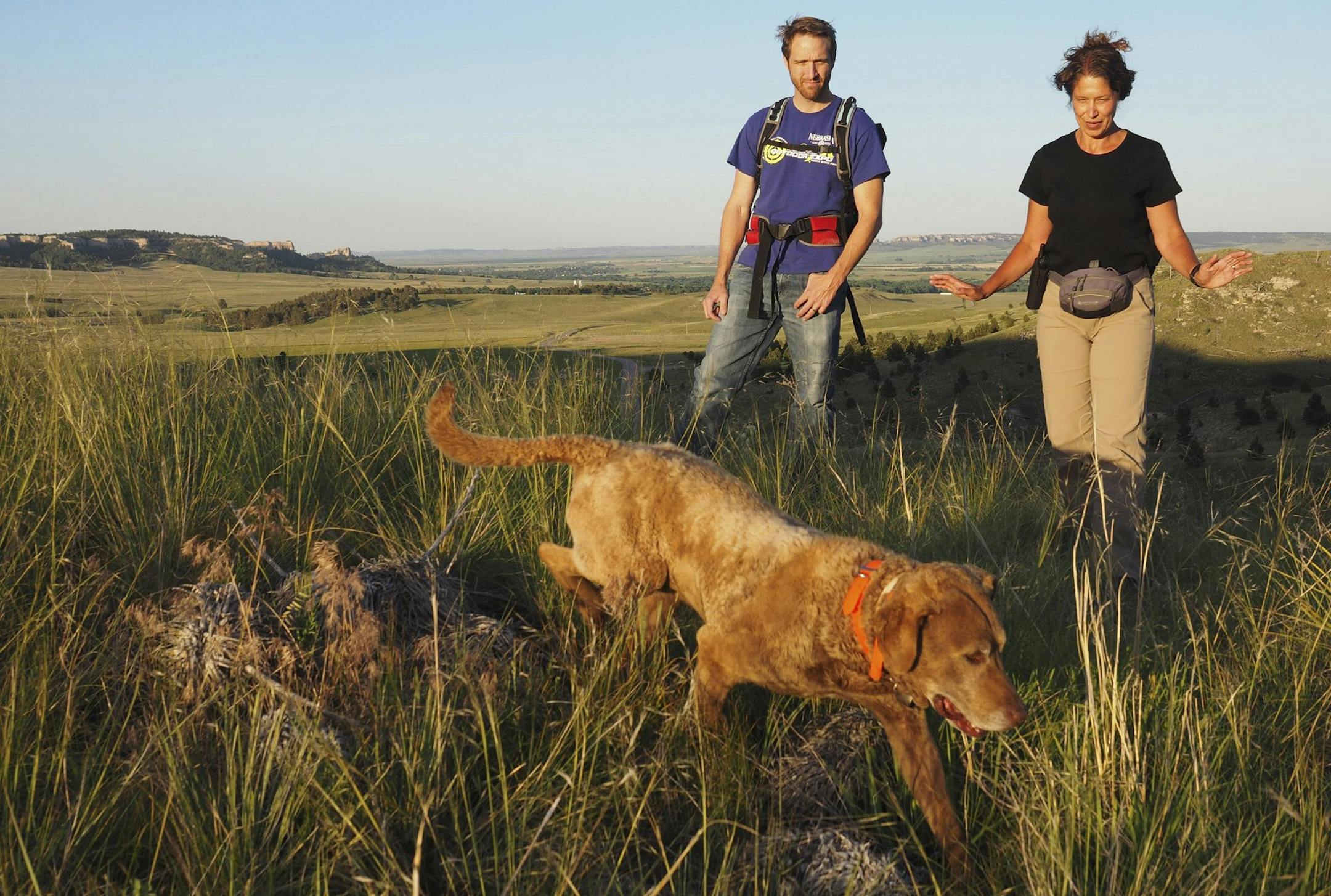 In this Thursday, June 22, 2017 photo, Karen DeMatteo, right, and Sam Wilson signal to her dog, Train, , in Fort Robinson State Park, Neb. (David Hendee/Omaha World-Herald via AP)