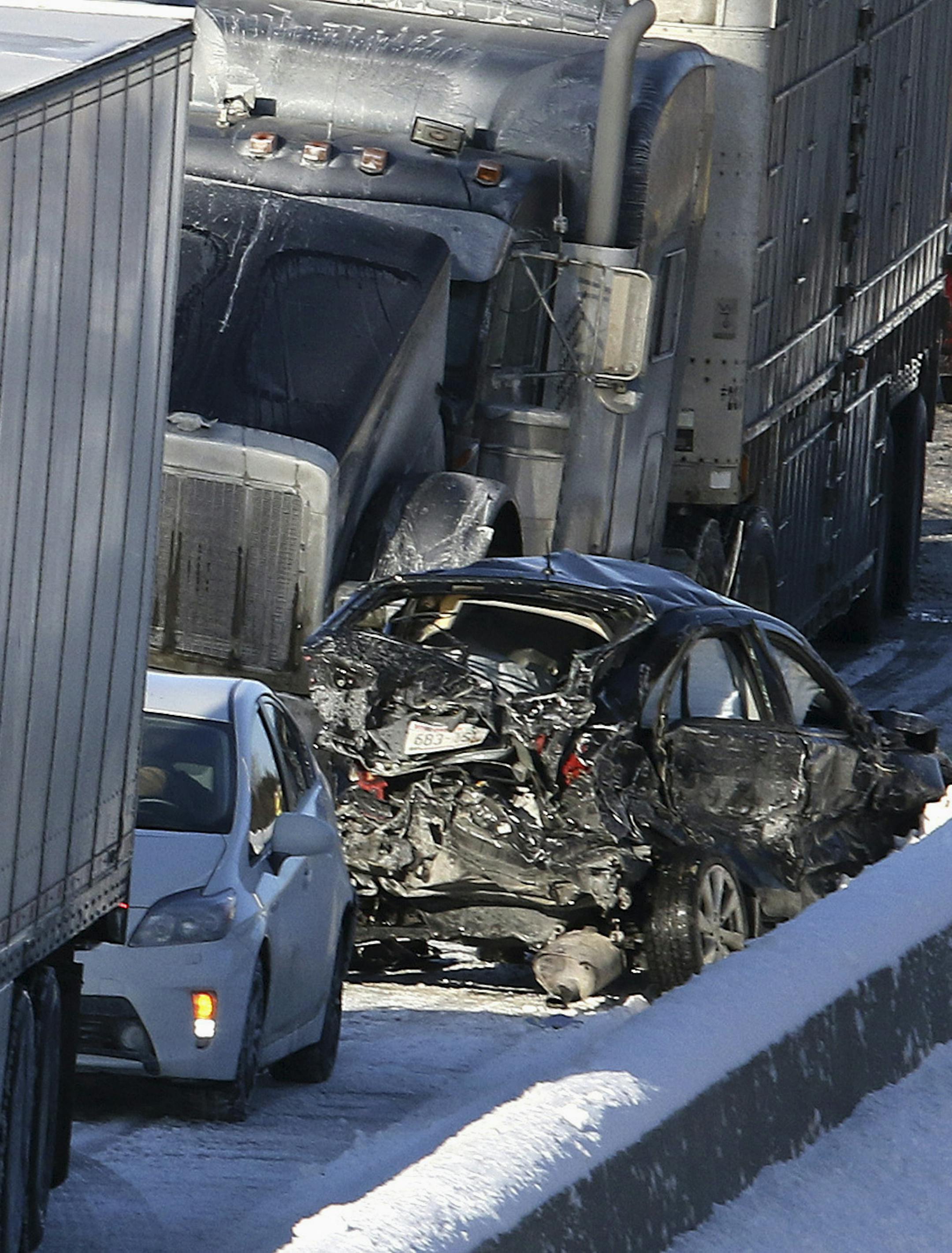 Damaged cars sit between two semi-trucks after a chain-reaction accident involving over 10 vehicles near Huntley, Ill., on Friday, Jan. 9, 2015. Upwards of 30 vehicles were involved in multiple crashes and weather-related incidents on Interstate 90 on Friday morning. In total, there were about eight people transported to area hospitals, but there were no extrications or life-threatening injuries. (AP Photo/Northwest Herald, H. Rick Bamman)