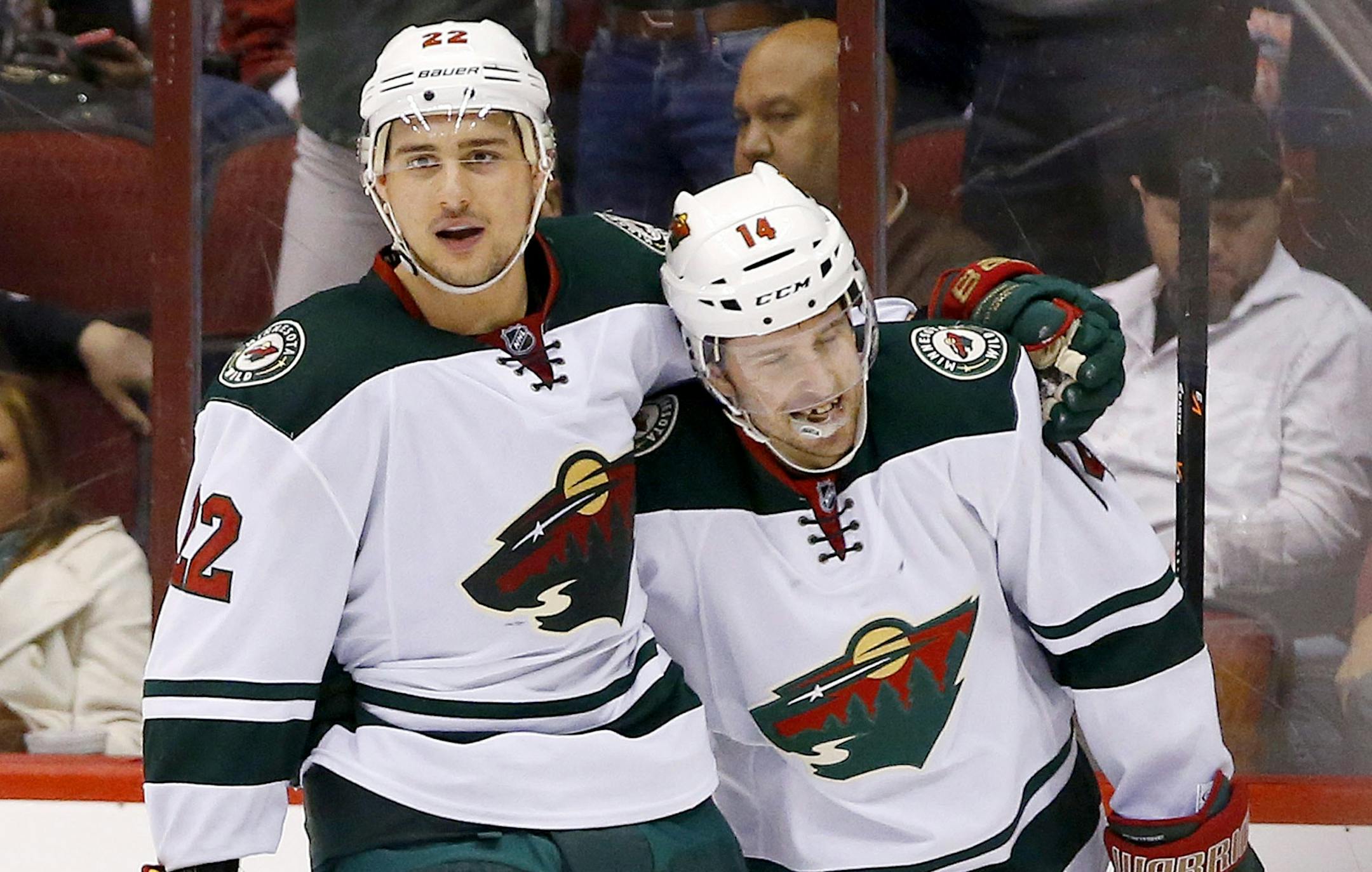 Minnesota Wild's Justin Fontaine (14) smiles as the gets a hug from teammate Nino Niederreiter (22), of Switzerland, after Fontaine notched his third score of the night for a hat trick against the Phoenix Coyotes, scoring the final time during the third period in an NHL hockey game Thursday, Jan. 9, 2014, in Glendale, Ariz. The Wild defeated the Coyotes 4-1. (AP Photo/Ross D. Franklin)
