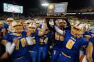 St. Michael-Albertville players celebrated with their 5A championship trophy after defeating St. Thomas Academy 28-21, in the Class 5A championship ga