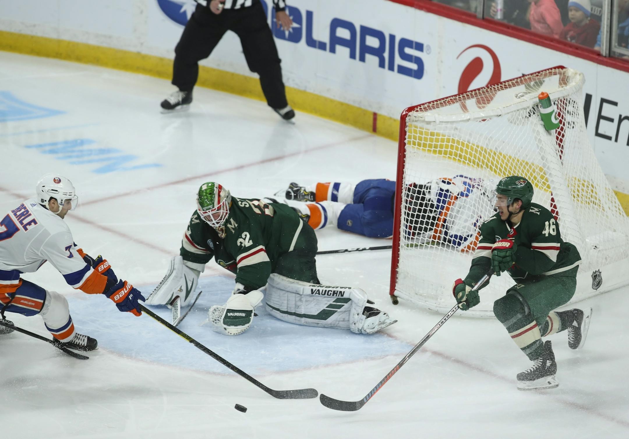 After Minnesota Wild goaltender Alex Stalock (32) stopped New York Islanders center Mathew Barzal (13) when he had a third period breakaway, Wild defenseman Jared Spurgeon (46) reached to clear the puck ahead of Islanders right wing Jordan Eberle (7).