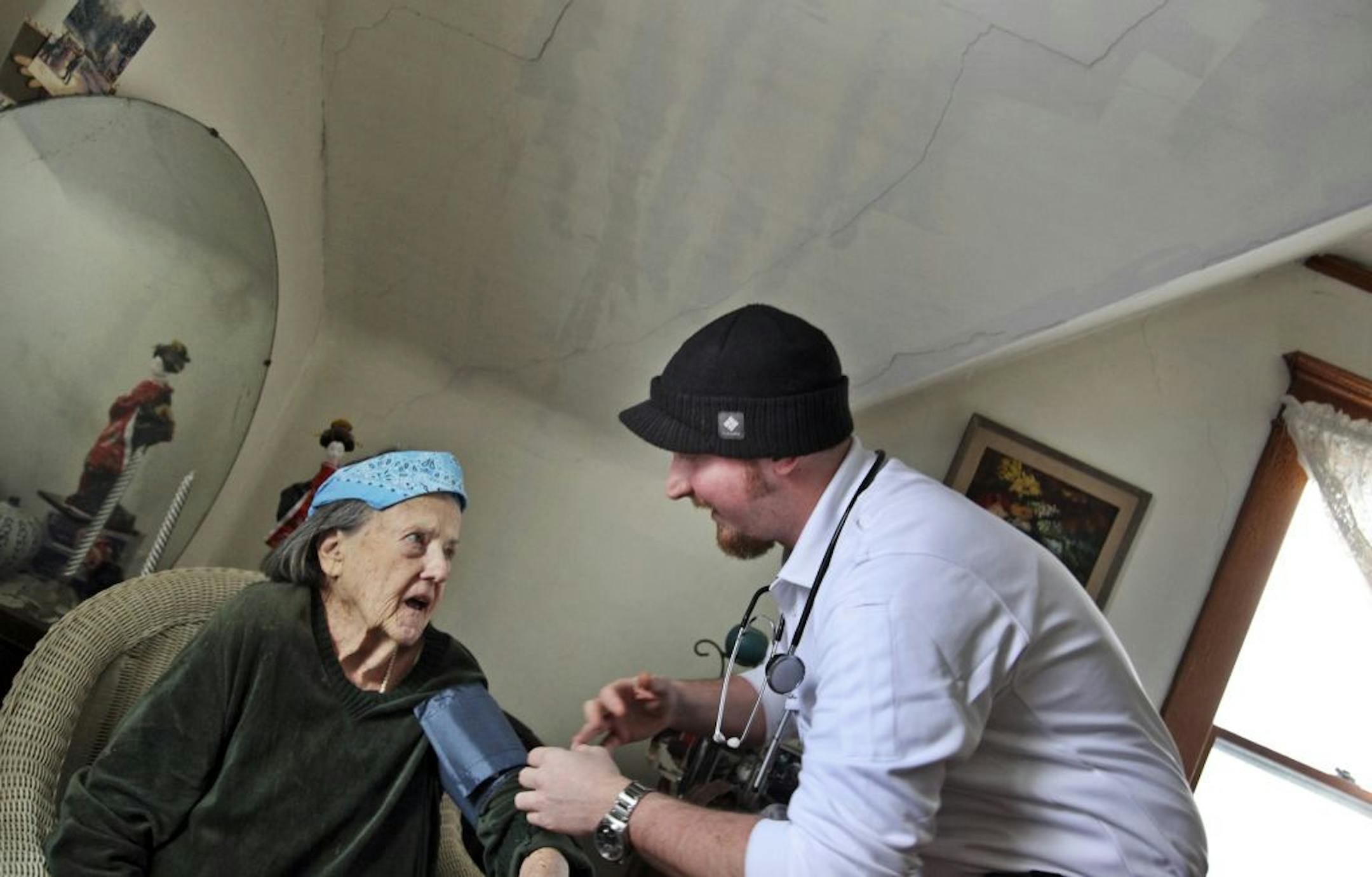 Community paramedic Peter Carlson checked the blood pressure of 86-year-old Erika Bruvelis of south Minneapolis during a home visit.