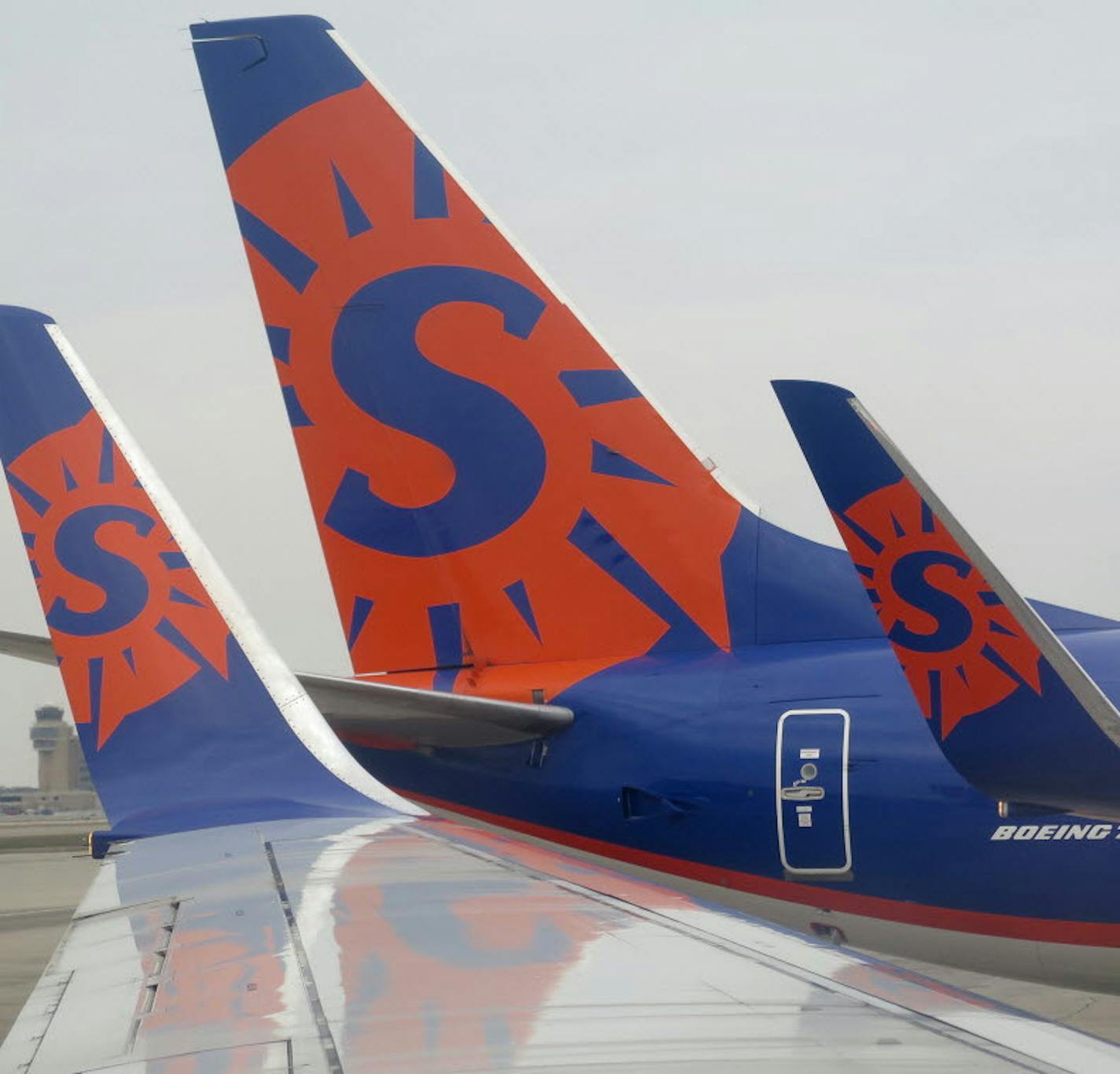 Sun Country airlines logo on 737 wing tips and tail at Humphrey terminal at the Minneapolis-St. Paul International Airport.