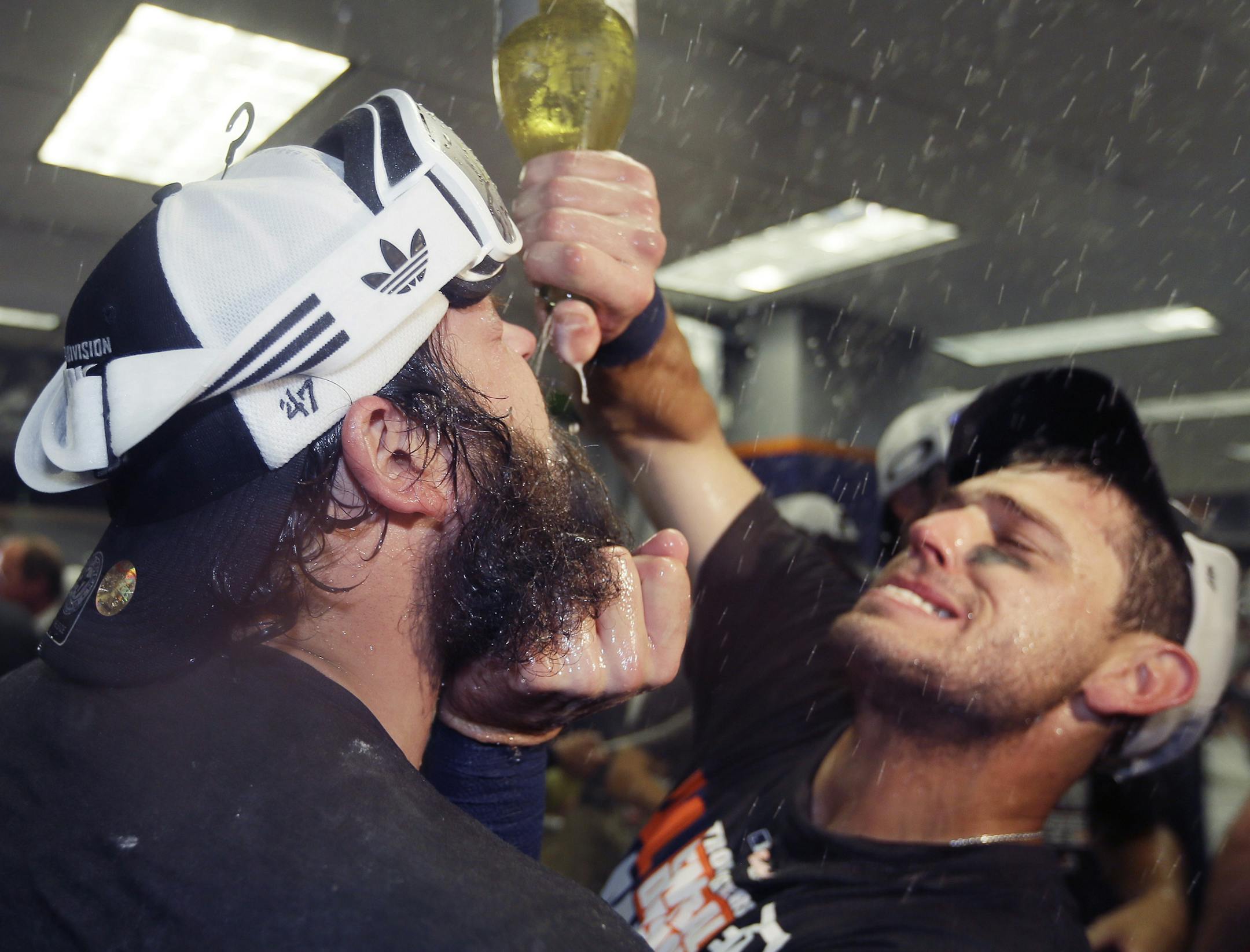 Detroit Tigers second baseman Ian Kinsler, right, gives relief pitcher Joba Chamberlain a drink after the team clinched the AL Central with a 3-0 win over the Minnesota Twins ina baseball game in Detroit, Sunday, Sept. 28, 2014. (AP Photo/Carlos Osorio)