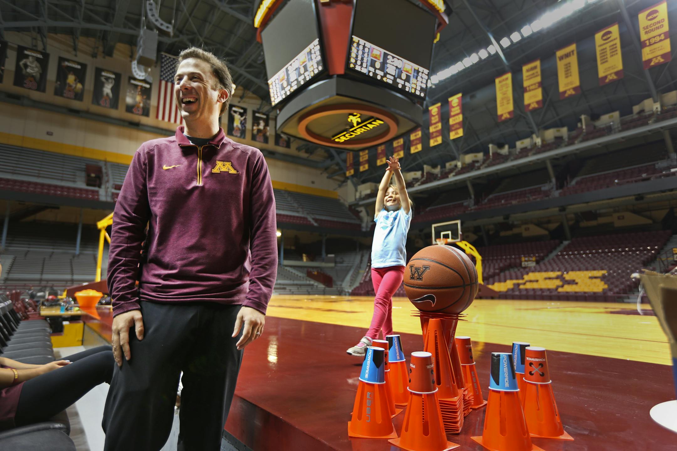 Richard Pitino with two of his children at Williams Arena earlier this season. Pitino said he no longer gets asked on the ride to school if Daddy's team lost again.