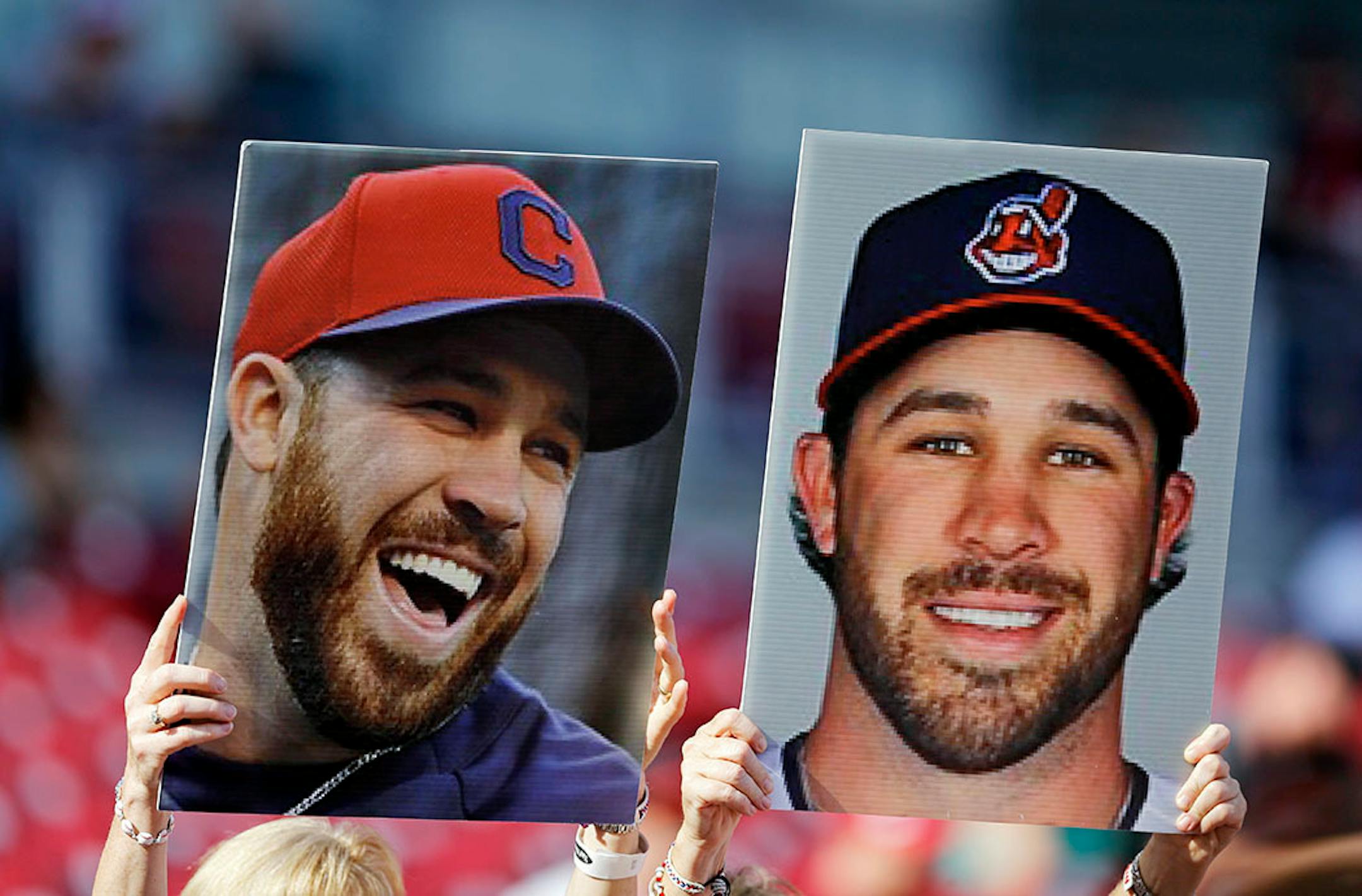 Fans hold up photos of American League's Jason Kipnis,of the Cleveland Indians, during batting practice before the MLB All-Star baseball game, Tuesday, July 14, 2015, in Cincinnati.