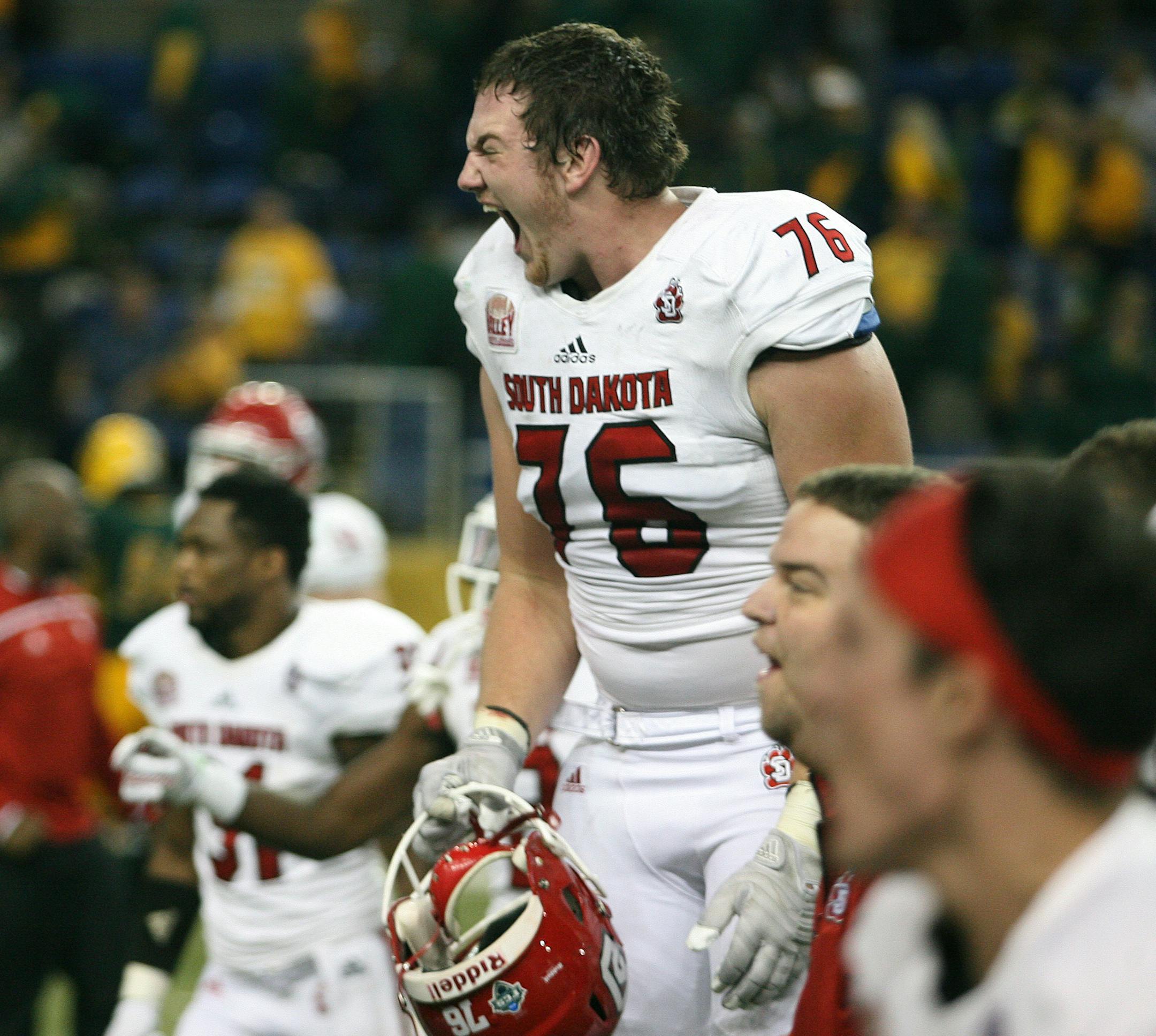 South Dakota linebacker Nick Jensen (76) celebrates with teammates following a last second winning field goal over North Dakota State 24-21 in an NCAA college football game Saturday, Oct. 17, 2015, in Fargo, N.D. (AP Photo/Bruce Crummy)