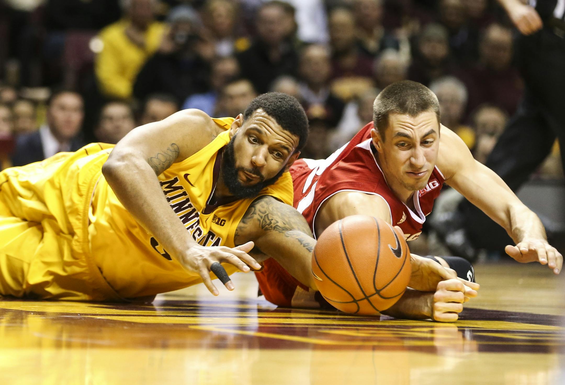Minnesota’s Maurice Walker dove for a loose ball with Wisconsin’s Josh Gasser (21) during the second half.