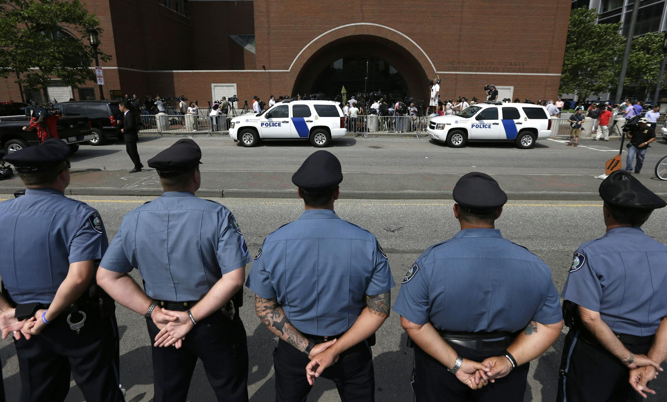 Massachusetts Institute of Technology police officers form a line in front of the federal courthouse in Boston prior to the arraignment of Boston Marathon bombing suspect Dzhokhar Tsarnaev Wednesday, July 10, 2013. MIT police officer Sean Collier was allegedly killed by the Marathon Bombing suspects. The 19-year-old Tsarnaev has been charged with using a weapon of mass destruction. (AP Photo/Steven Senne)