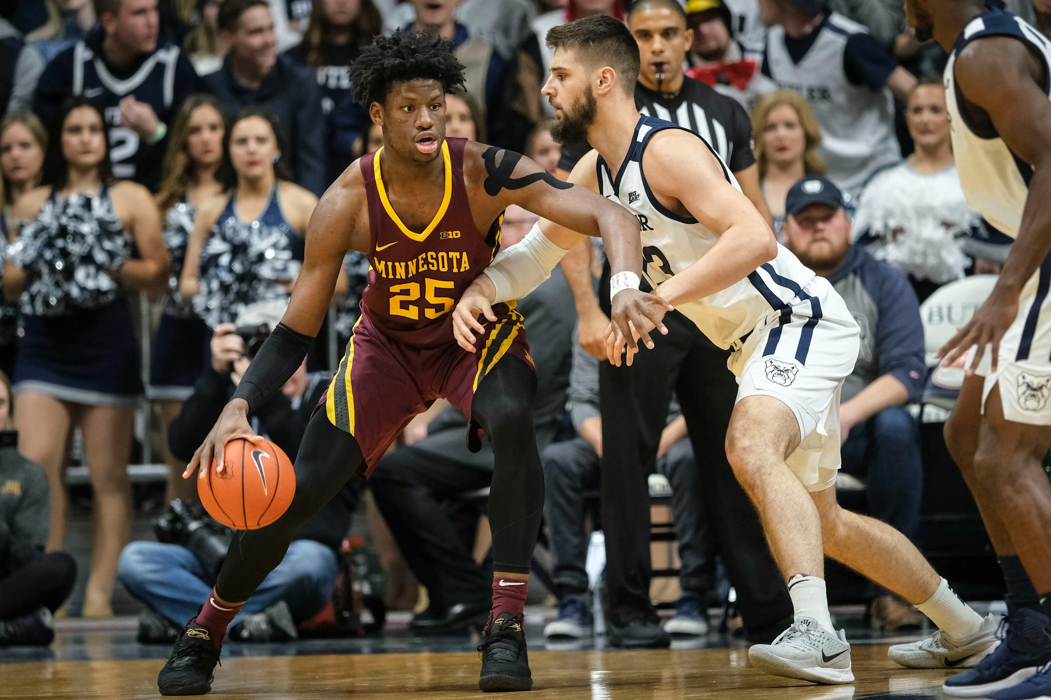 Gophers center Daniel Oturu backs Butler forward Bryce Golden toward the basket.
