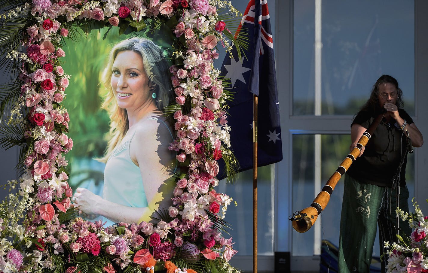 FILE - In this Aug. 11, 2017, file photo, Johanna Morrow plays the didgeridoo during a memorial service for Justine Ruszczyk Damond at Lake Harriet in Minneapolis. Defense attorneys want charges dismissed against a former Minneapolis police officer who shot and killed the Australian woman last year. Attorneys for ex-officer Mohamed Noor argue in motions filed Wednesday, Aug. 15, 2018, that the charges should be dismissed because of prosecutorial misconduct and lack of probable cause. (Aaron Lavi