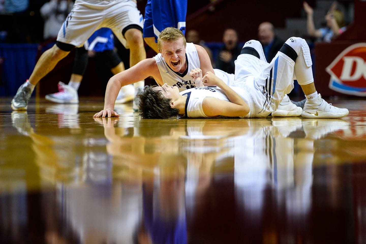 North Woods forward Tate Olson (15) celebrates on the floor with guard Cade Goggleye (3) after Goggleye hit a buzzer beating 3-pointer to beat Central Minnesota Christian in the 1A state tournament quarterfinals.