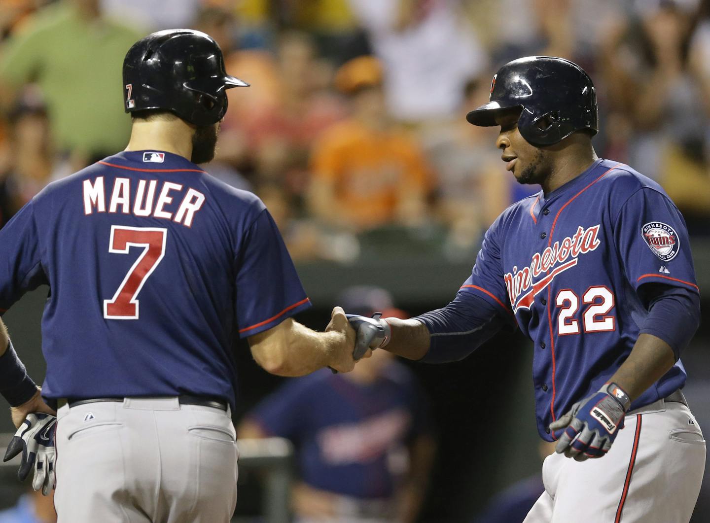 Minnesota Twins' Joe Mauer, left, shakes hands with teammate Miguel Sano after a home run last week in Baltimore.