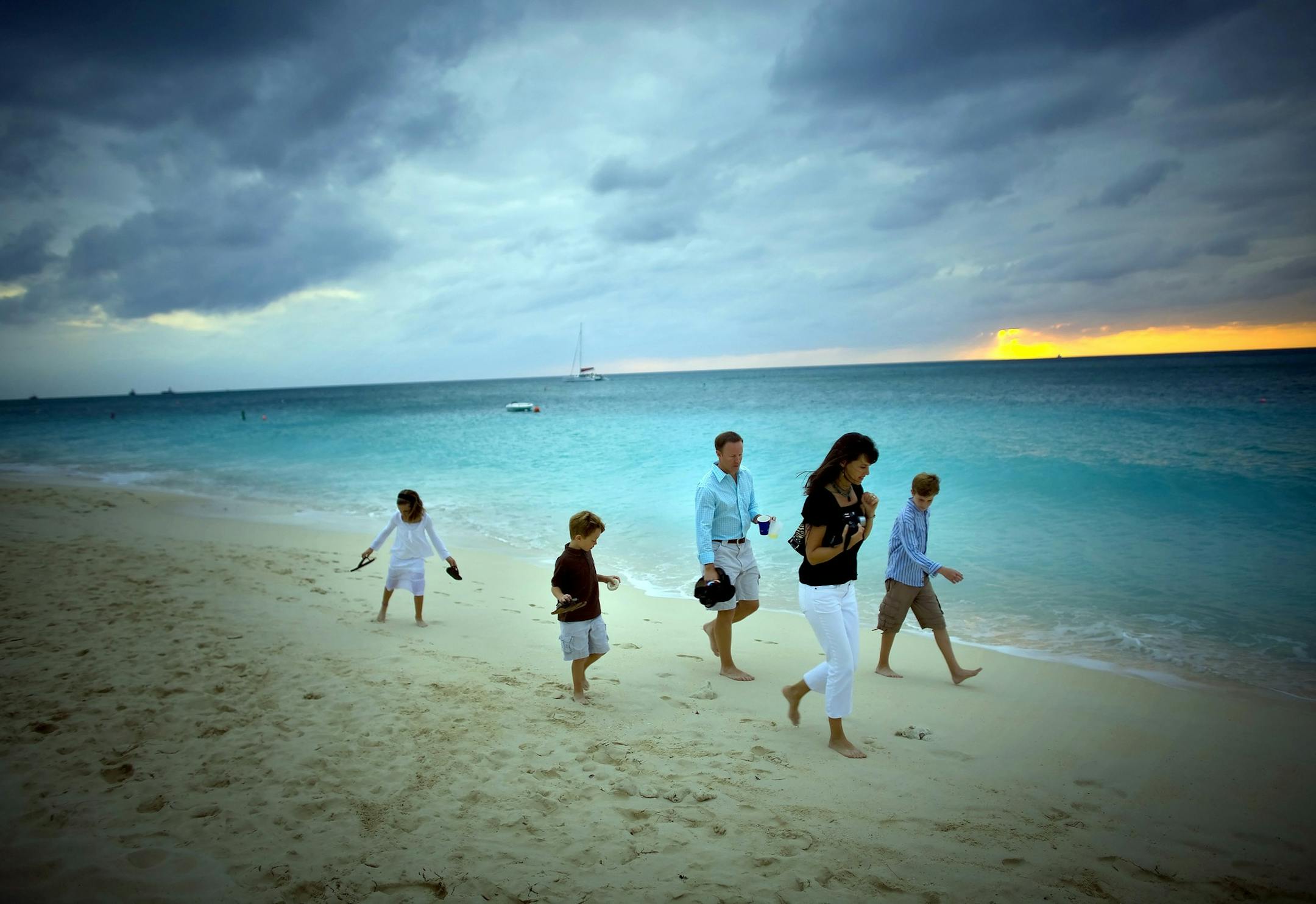 *FILE PHOTO* -- The Overcash family, from North Carolina, on an evening stroll along Seven Mile Beach in Grand Cayman in the Cayman Islands in November 2007. Grand Cayman, the largest of the three Cayman Islands, is perhaps best known for diving and offshore banking, but it's also toddler-friendly. (Robert Caplin/The New York Times) ORG XMIT: NYT17