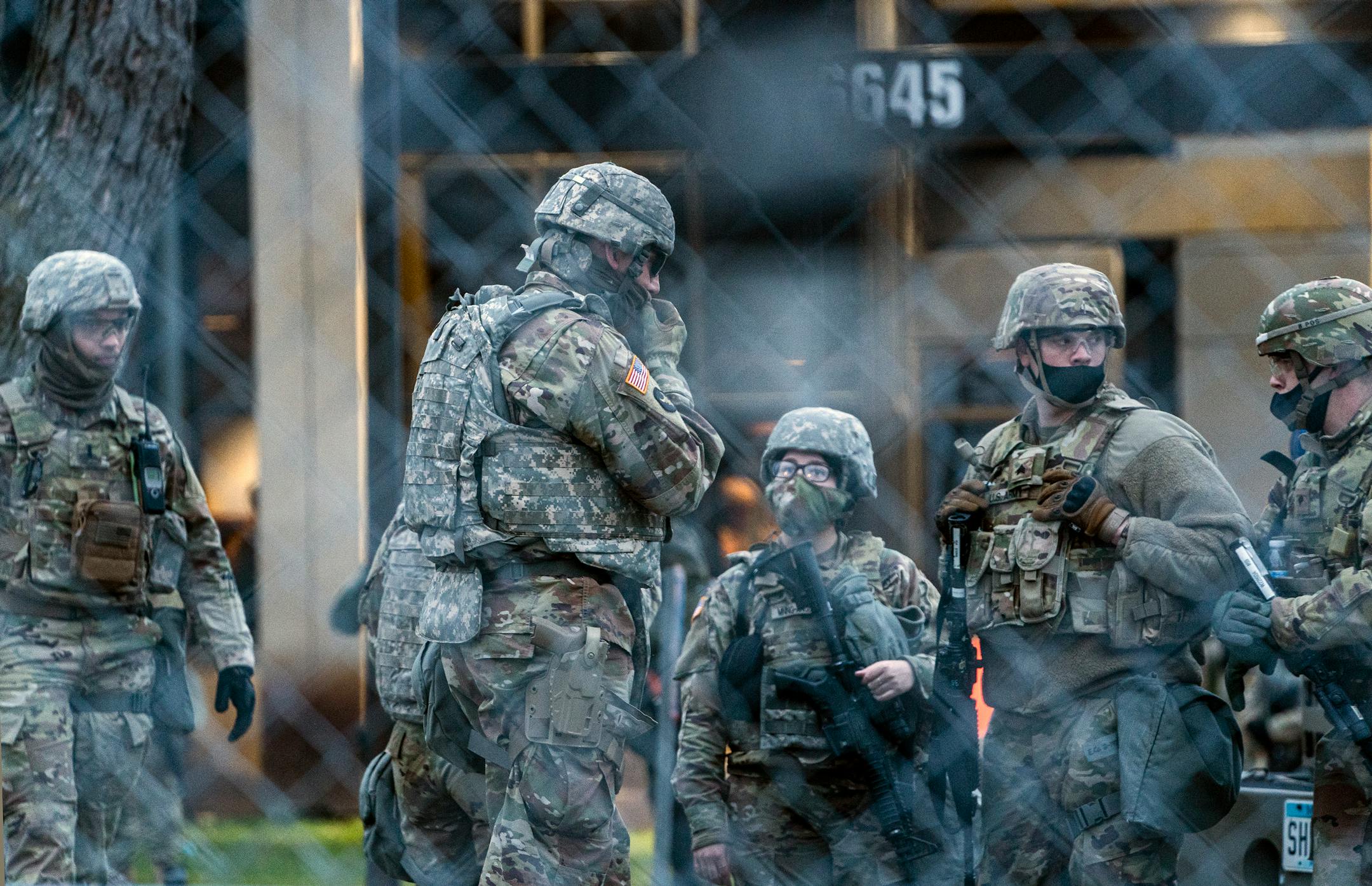 Law enforcement stand near as people protest near the Brooklyn Center Police Department in response to the fatal police shooting of Daunte Wright, Thursday, April 15, 2021 in Brooklyn Center, Minn.