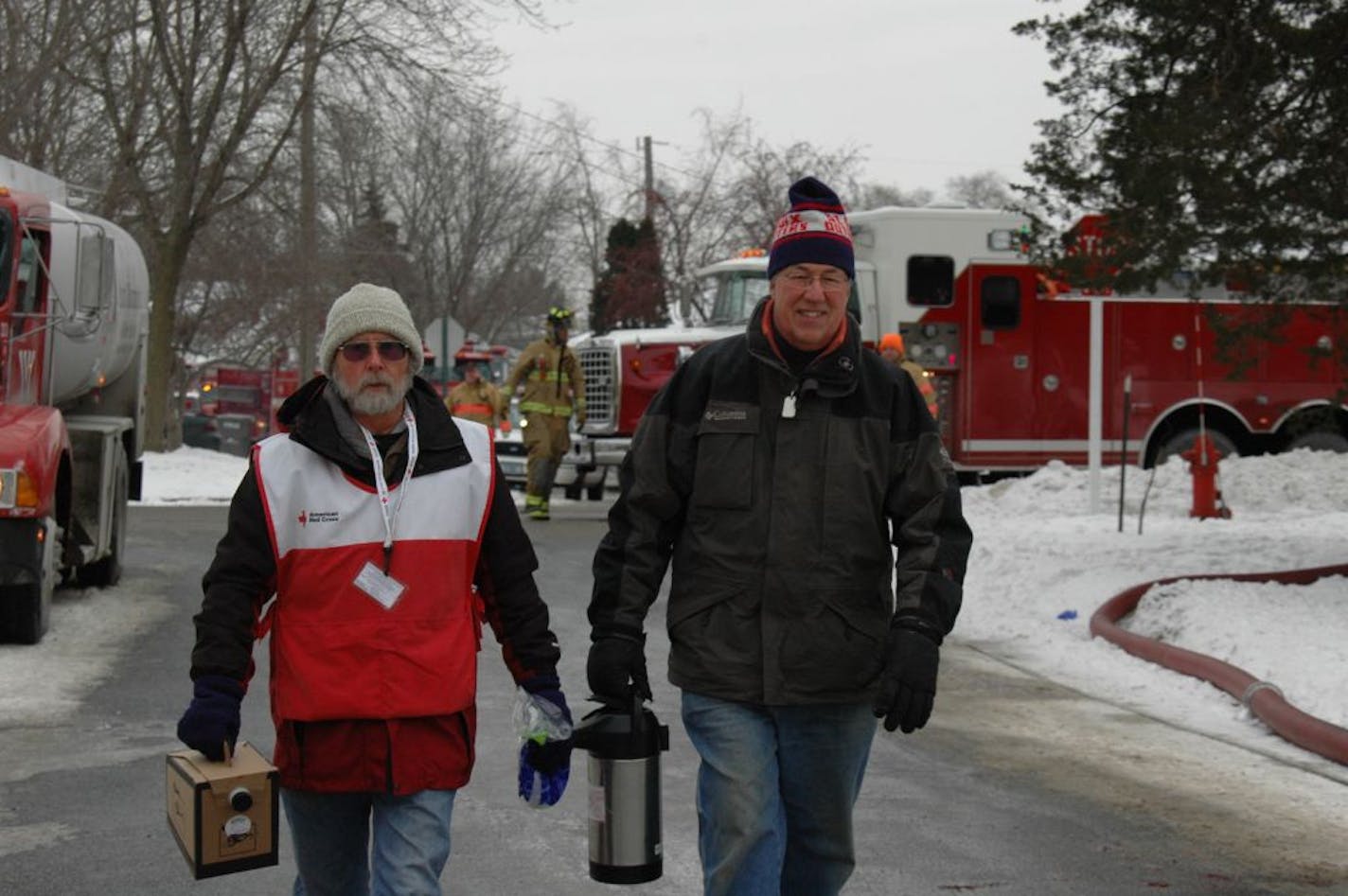 Photo #1: Retired Andersen Corporate Employee, Neil Frederick, serves food and beverages to local fire fighters who were battling a fire in Hudson, Wisconsin. Neil is one of our 79 trained Red Cross Disaster Action Team volunteers who make sure all needs are met 24 hours a day for people in need.