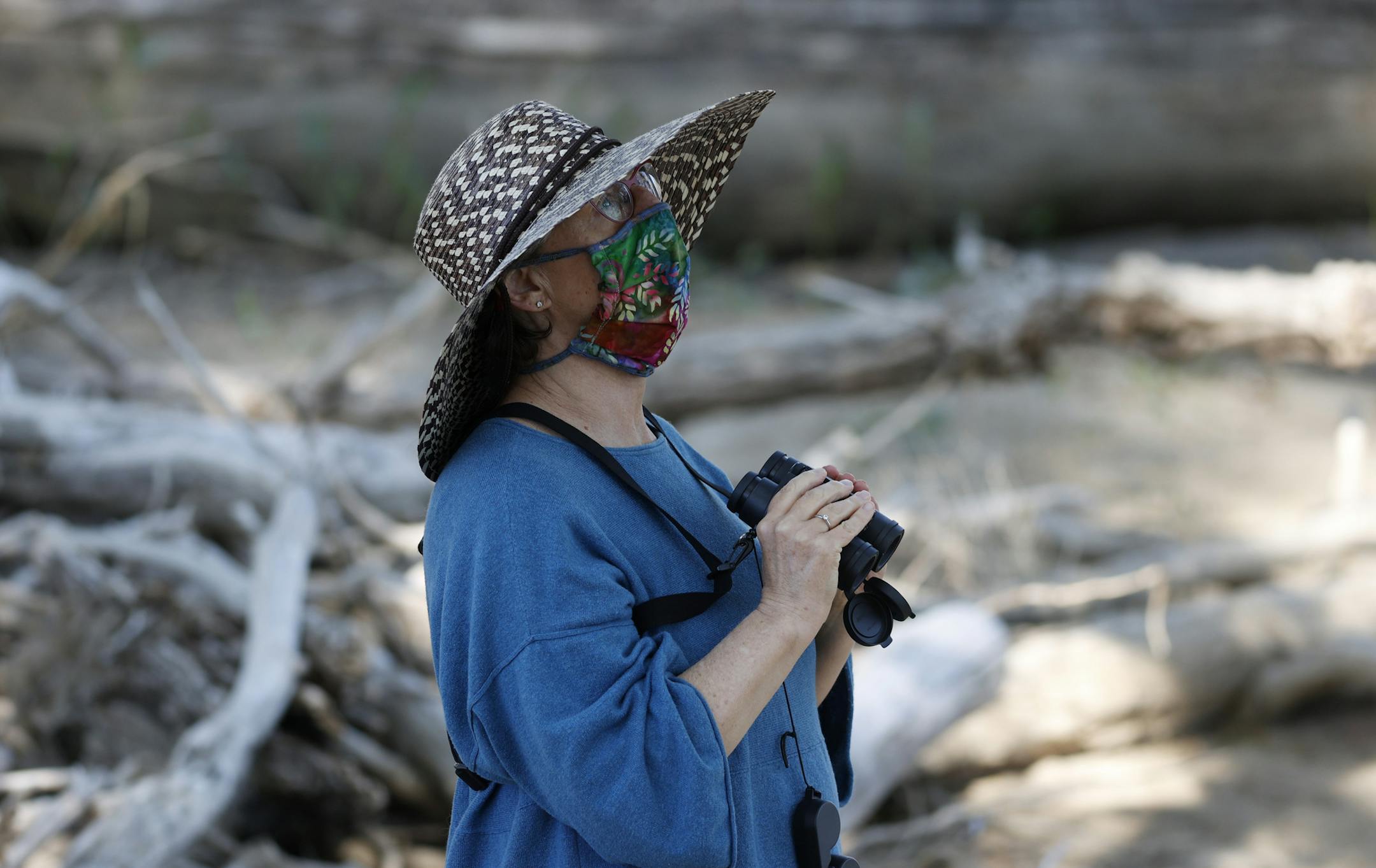 CORRECTS TO MAY 17 NOT MAY 16 - A birdwatcher wears a face mask while looking for birds at Barr Lake State Park, Sunday, May 17, 2020, near Brighton, Colo., during the coronavirus pandemic. (AP Photo/David Zalubowski)