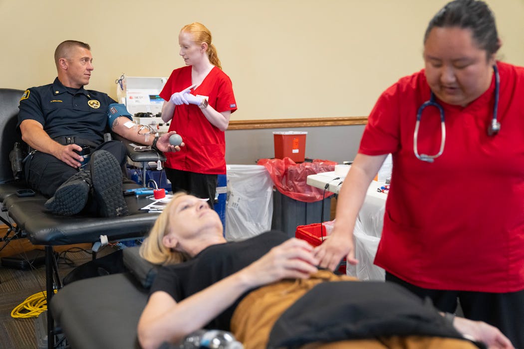 Left to right: St. Paul Police Commander Jesse Mollner speaks with Tessa LePlavy, a phlebotomist, as he donates blood while Janet Hathaway is helped by Summer Thao, a phlebotomist, during a Red Cross blood drive at Union Depot in St. Paul on Thursday, June 20.