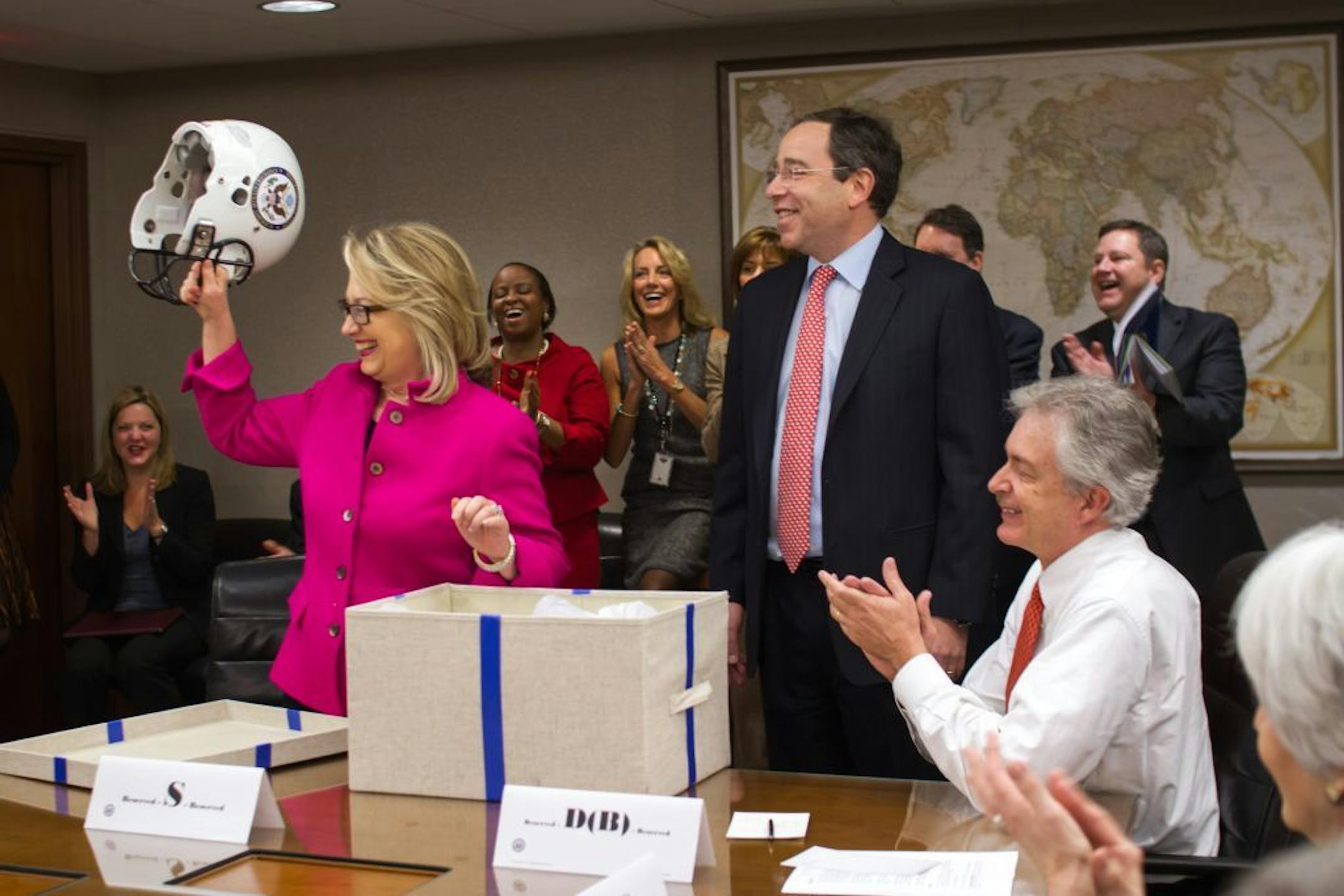 This handout photo provided by the State Department shows Secretary of State Hillary Rodham Clinton holding up a football helmet presented to her at the State Department in Washington, Monday, Jan. 7, 2013, as she returned to work on Monday after a month-long absence caused first by a stomach virus, then a fall and a concussion and finally a brief hospitalization for a blot clot near her brain.