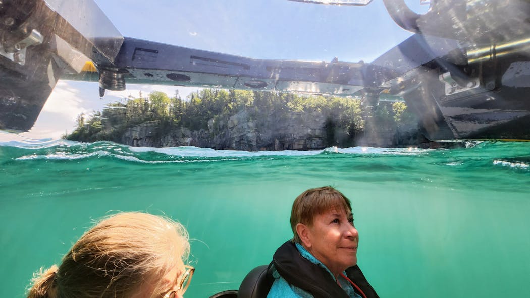 Passengers in a U-Boat Works submersible gaze above the surface of Lake Superior at the beginning of a dive near Silver Islet, Ontario.