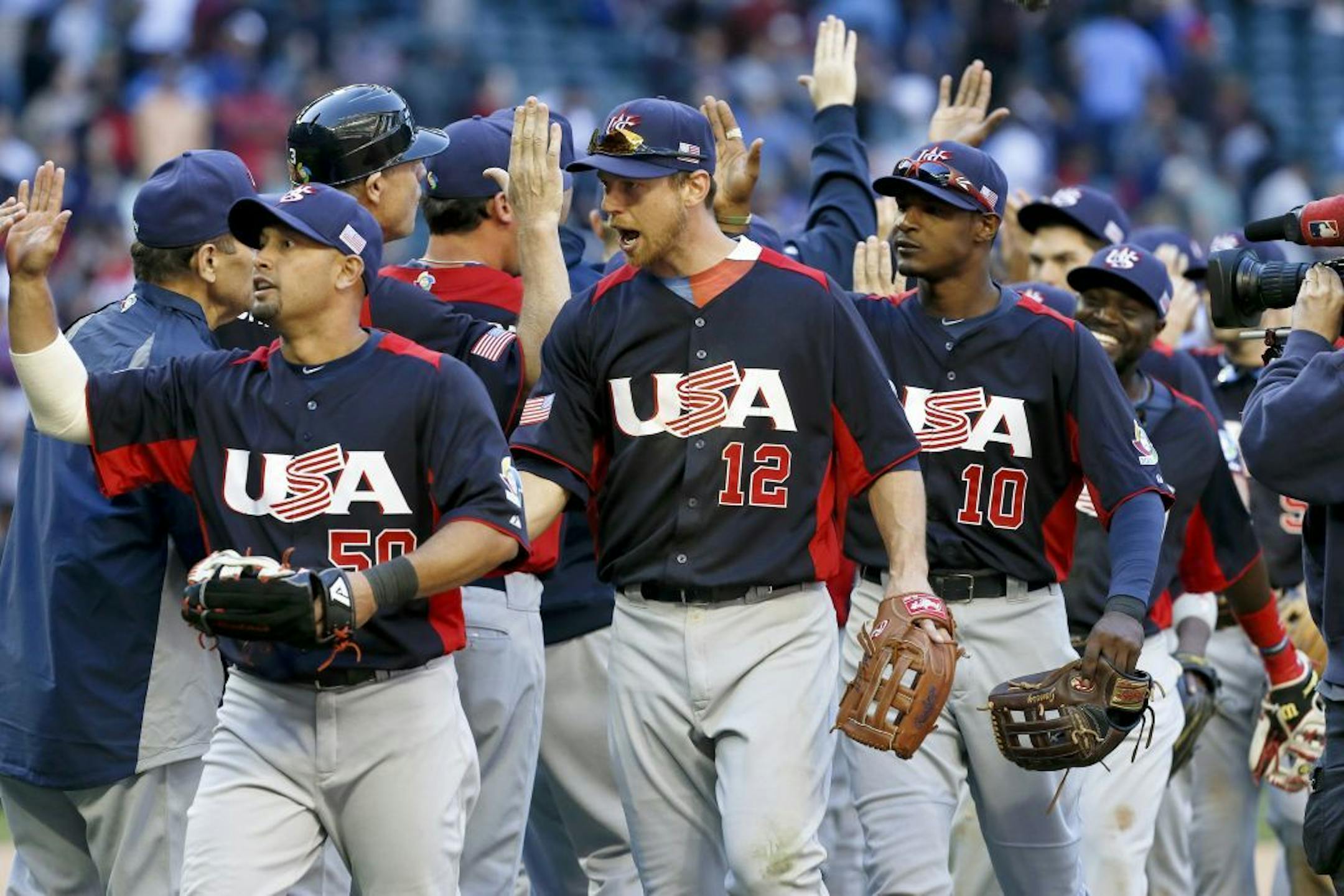 United States' Shane Victorino, left, Ben Zobrist (12) and Adam Jones (10) celebrate a win over Canada after the ninth inning in a World Baseball Classic baseball game on Sunday, March 10, 2013, in Phoenix. The United States defeated Canada 9-4.