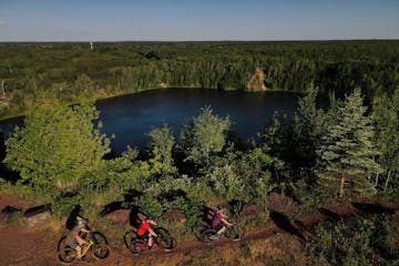 From left, Chuck Picard, Chuck Carlson and Sue Carlson biked toward the top of the Miner’s Mountain Overlook at Cuyuna Country State Recreation Area