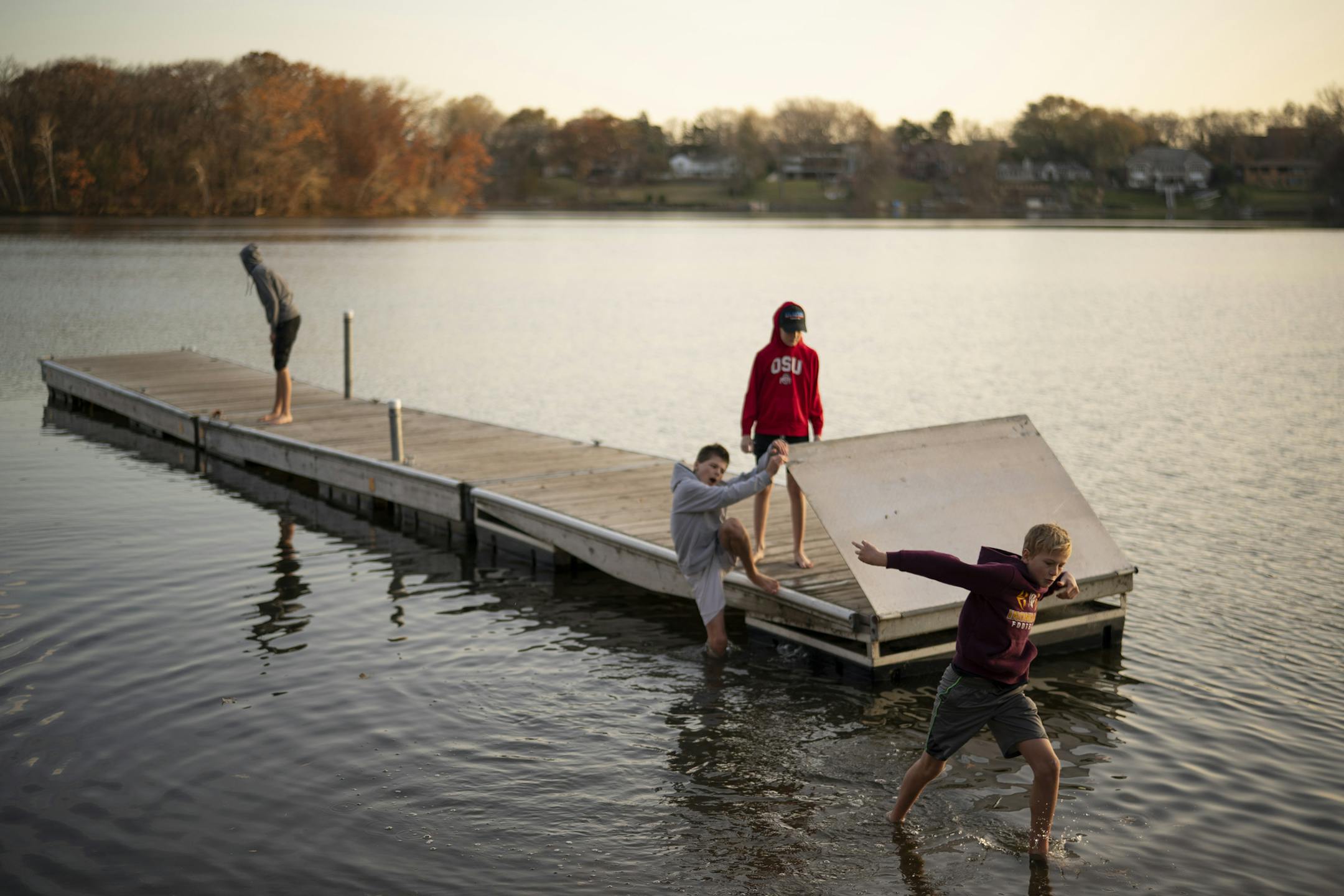 Jackson Arndt, Will Rehfuss, Ryan Becker and his brother, Nick, front to back, got back on shore after goofing off on the dock in Silver Lake while at Silverwood Park in St. Anthony Monday afternoon. ] JEFF WHEELER • jeff.wheeler@startribune.com Silverwood Park in St. Anthony was popular with walkers and others enjoying the warm temperatures late Monday afternoon, November 2, 2020.