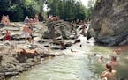 A bend in the rushing Pistynka River in Sheshory serves as a gathering spot for swimmers and sunbathers.