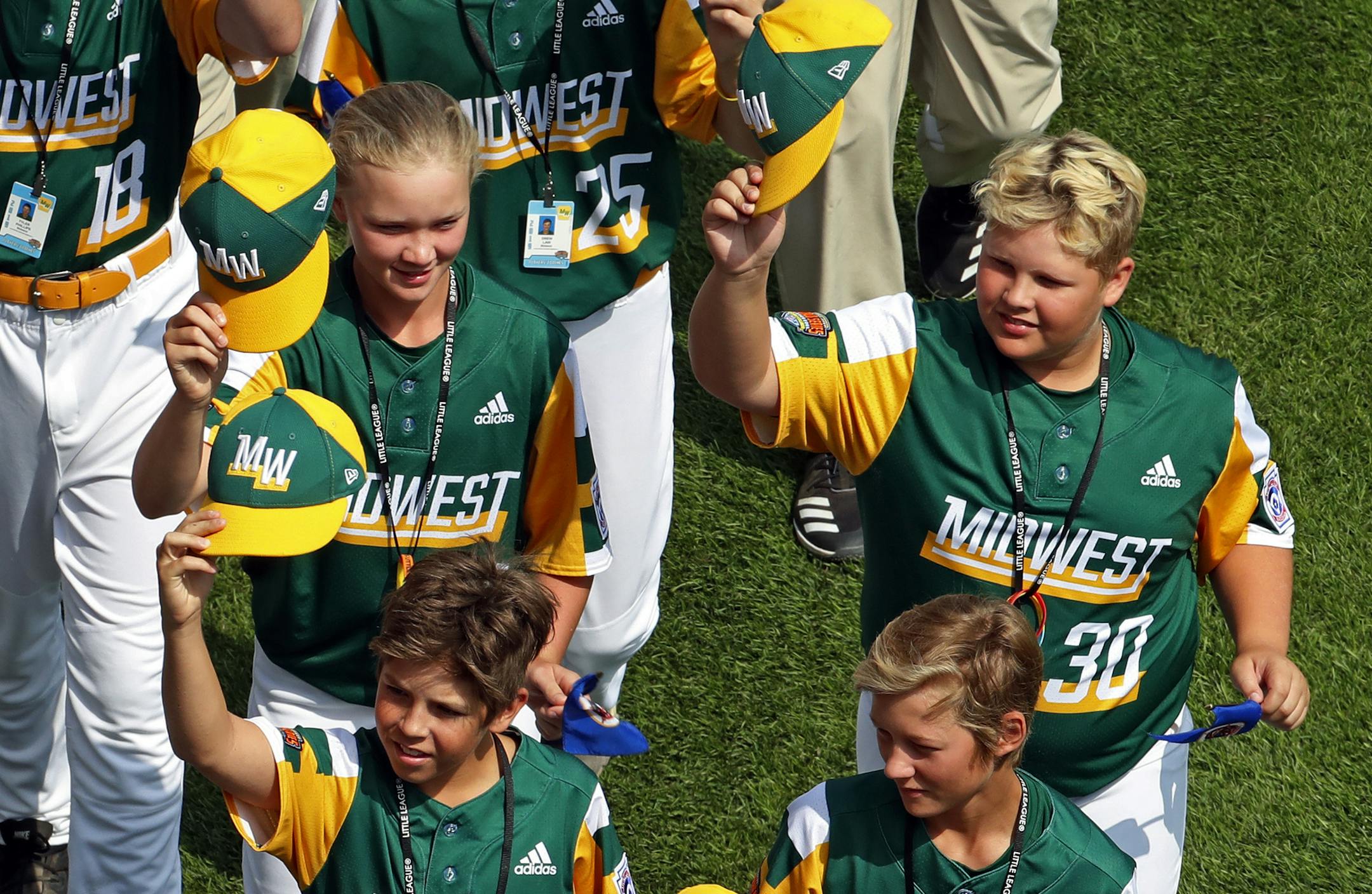 Maddy Freking, left center, and Jameson Kuznia (30) of the Midwest Region Champion Little League team from Coon Rapids, Minn., participate with their team in the opening ceremony of the 2019 Little League World Series baseball tournament in South Williamsport, Pa., Thursday, Aug. 15, 2019. (AP Photo/Gene J. Puskar)