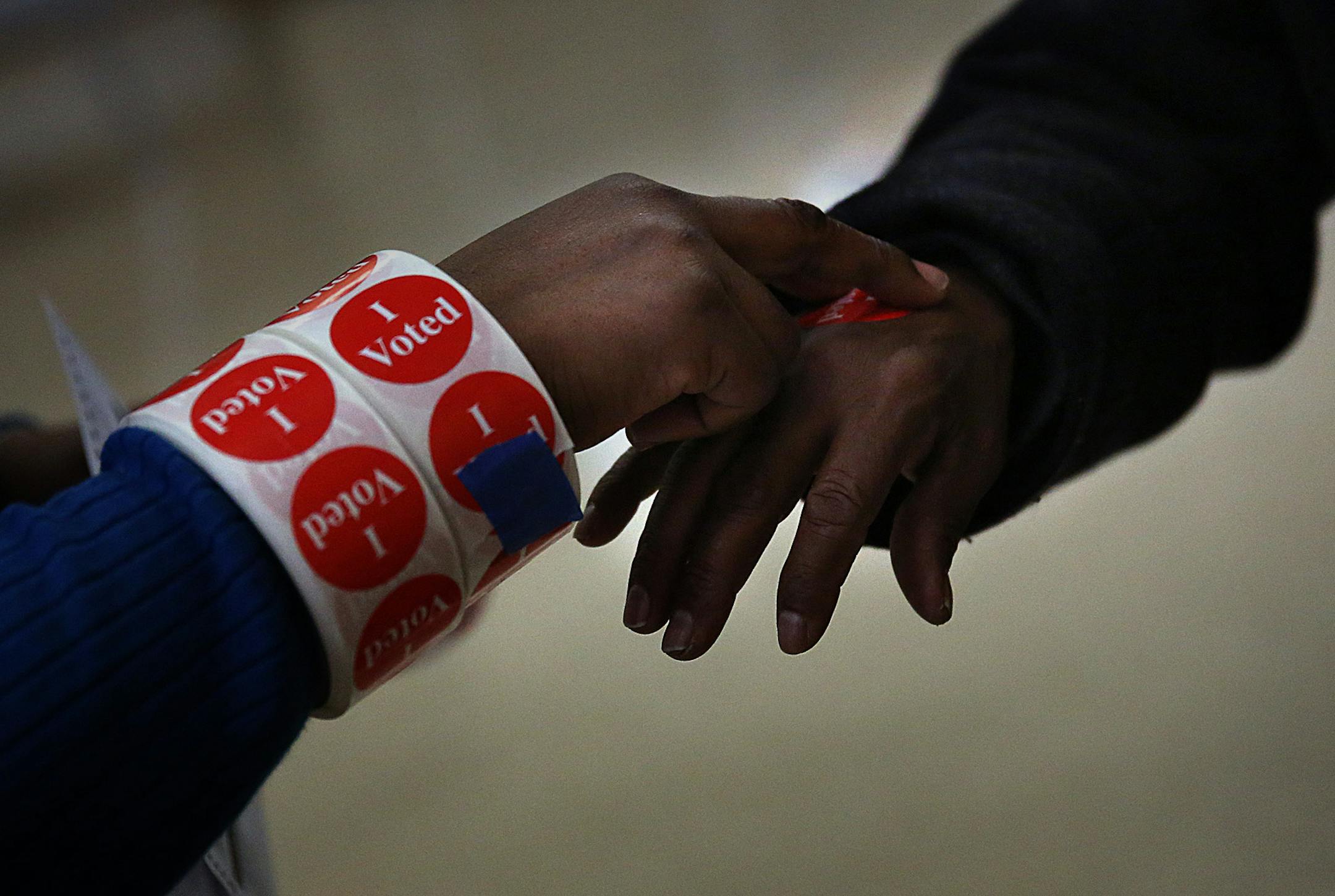 Brenda Bell Brown, assistant chief election judge, gave a sticker to a voter at the Elliot Park Recreation Center. ] (JIM GEHRZ/STAR TRIBUNE) / November 5, 2013, Minneapolis, MN ‚Äì BACKGROUND INFORMATION- Voters cast their ballots at the Elliot Park Recreation Center in Minneapolis. The city‚Äôs ballot includes more than 30 candidates for mayor, with ranked-choice voting being used to determine the winner.