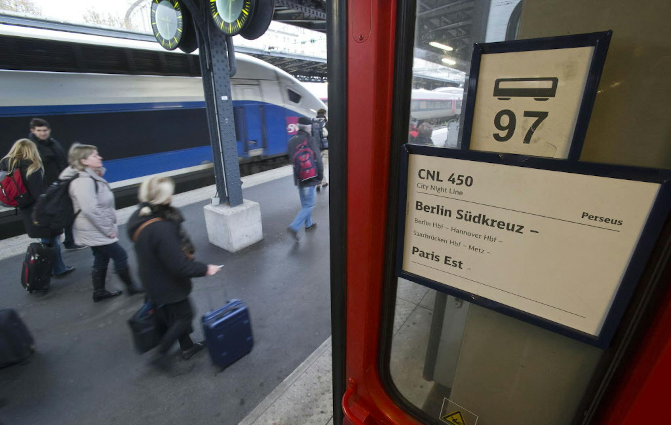 Travelers walk past a sign showing the destination upon their arrival from Berlin at Gare de l'Est train station in Paris, France, Friday, Dec. 12, 2014. German railway company Deutsche Bahn is ending the sleeper service between Paris and Berlin this week, citing unsustainable losses. The service has been running since before World War II, and used to go all the way to Moscow. A high speed train (TGV) is in the background. (AP Photo/Michel Euler)
