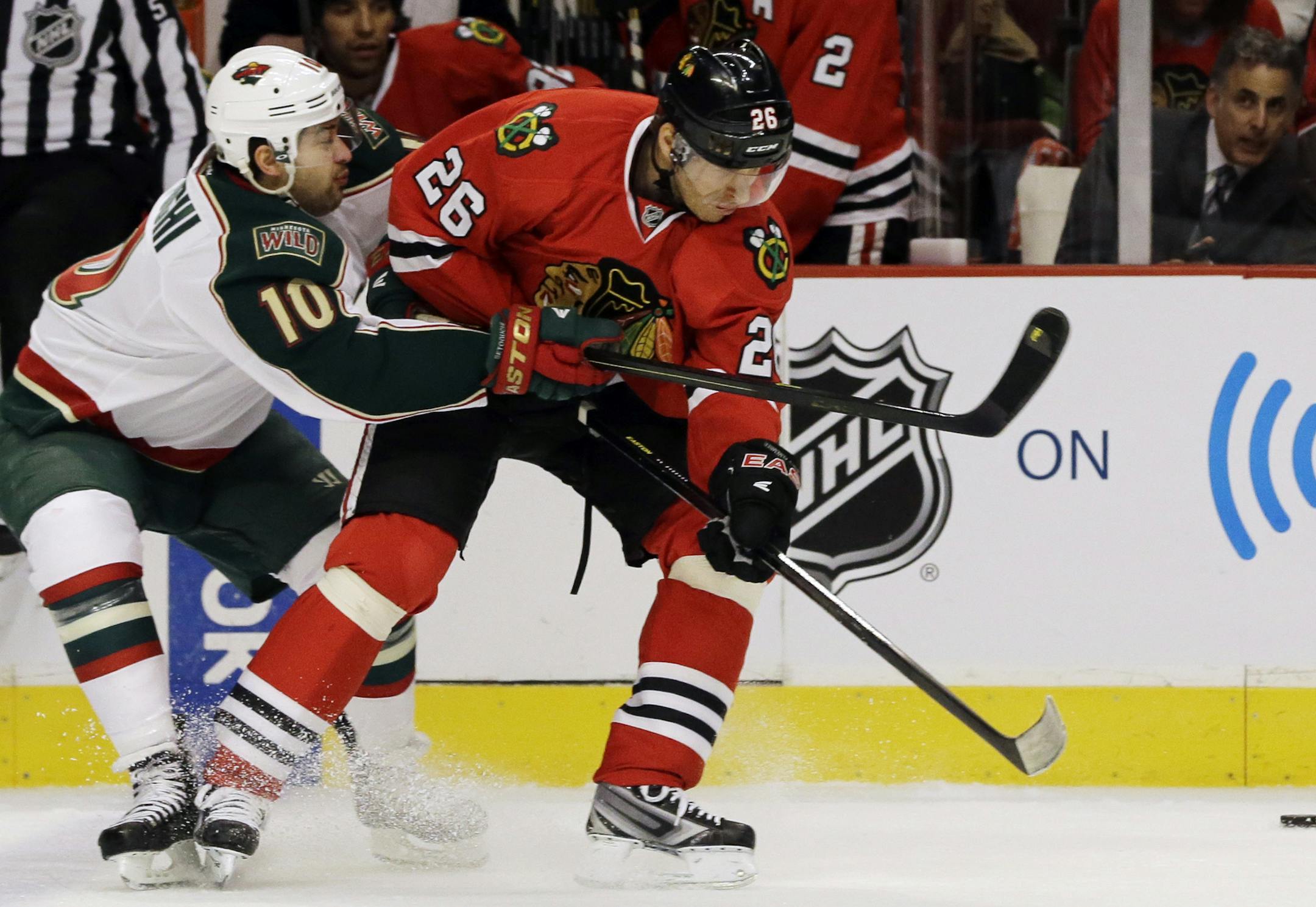 The Wild’s Devin Setoguchi, left, battled for the puck with Chicago’s Michal Handzus during the first period Friday in Chicago.