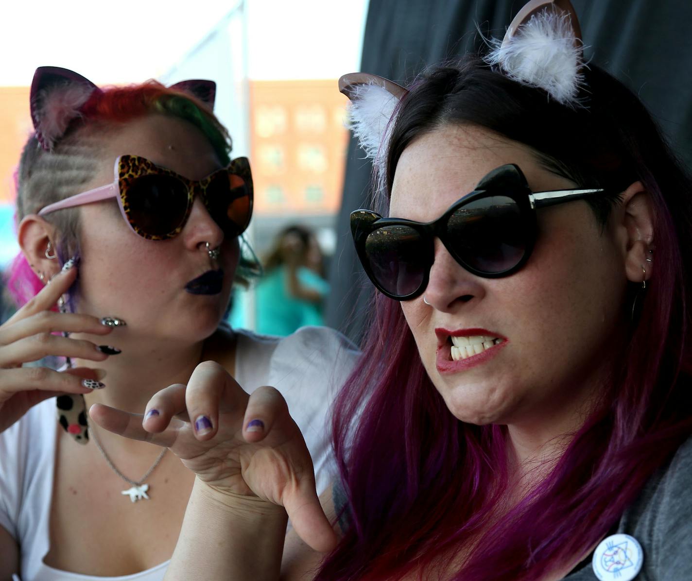 Lacie Zeiler, of Minneapolis, right and Renata Shaffer-Gottschalk make cat faces before the start of the Cat Video Festival hosted by the Walker Arts Center. ] (KYNDELL HARKNESS/STAR TRIBUNE) kyndell.harkness@startribune.com Cat video festival at CHS Field in St Pauls, Min., Wednesday August 12, 2015.