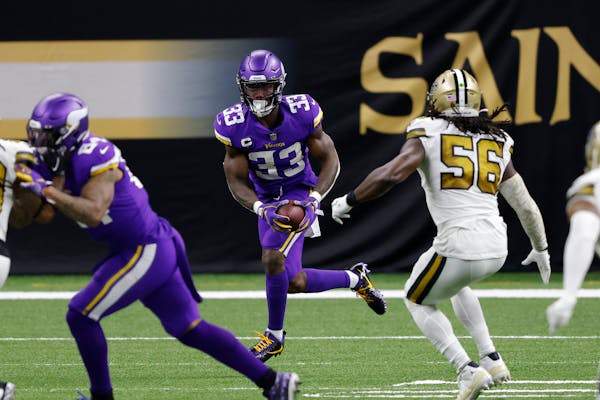 Minnesota Vikings running back Dalvin Cook (33) runs past New Orleans Saints outside linebacker Demario Davis (56) during an NFL football game, Friday