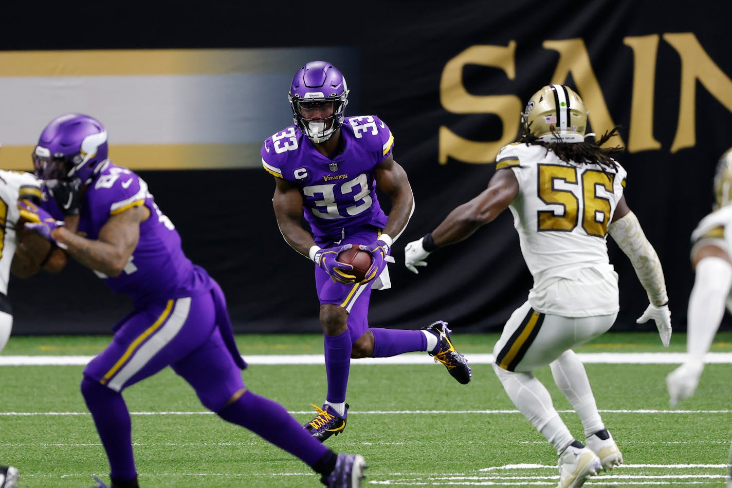 Minnesota Vikings running back Dalvin Cook (33) runs past New Orleans Saints outside linebacker Demario Davis (56) during an NFL football game, Friday, Dec. 25, 2020, in New Orleans. (AP Photo/Tyler Kaufman)