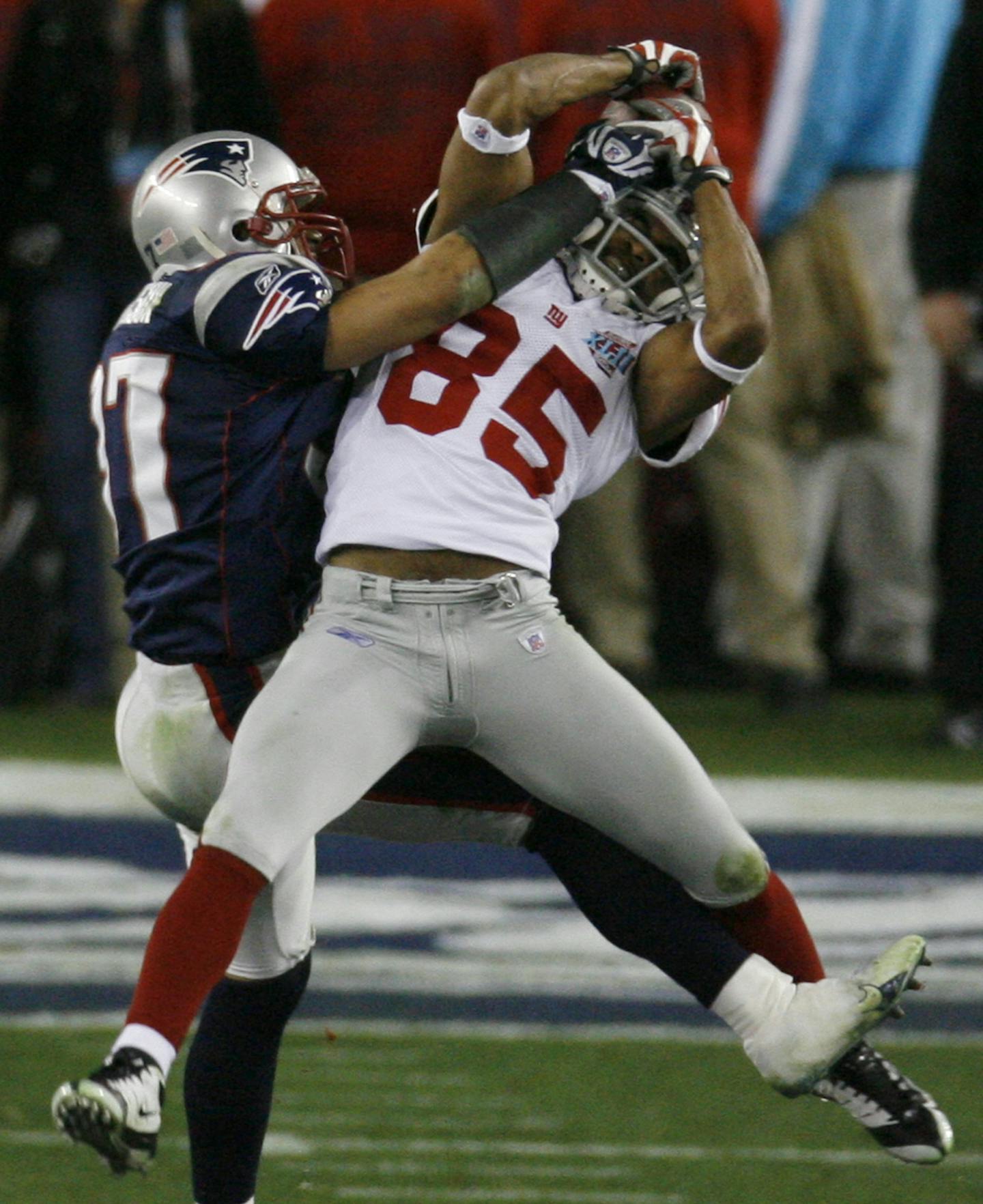 New York Giants receiver David Tyree (85) catches a complete pass as New England Patriots safety Rodney Harrison (37) tries to break up the play in the fourth quarter during the Super Bowl XLII football game at University of Phoenix Stadium on Sunday, Feb. 3, 2008 in Glendale, Ariz. (AP Photo/Ross D. Franklin) ORG XMIT: NYEOTK