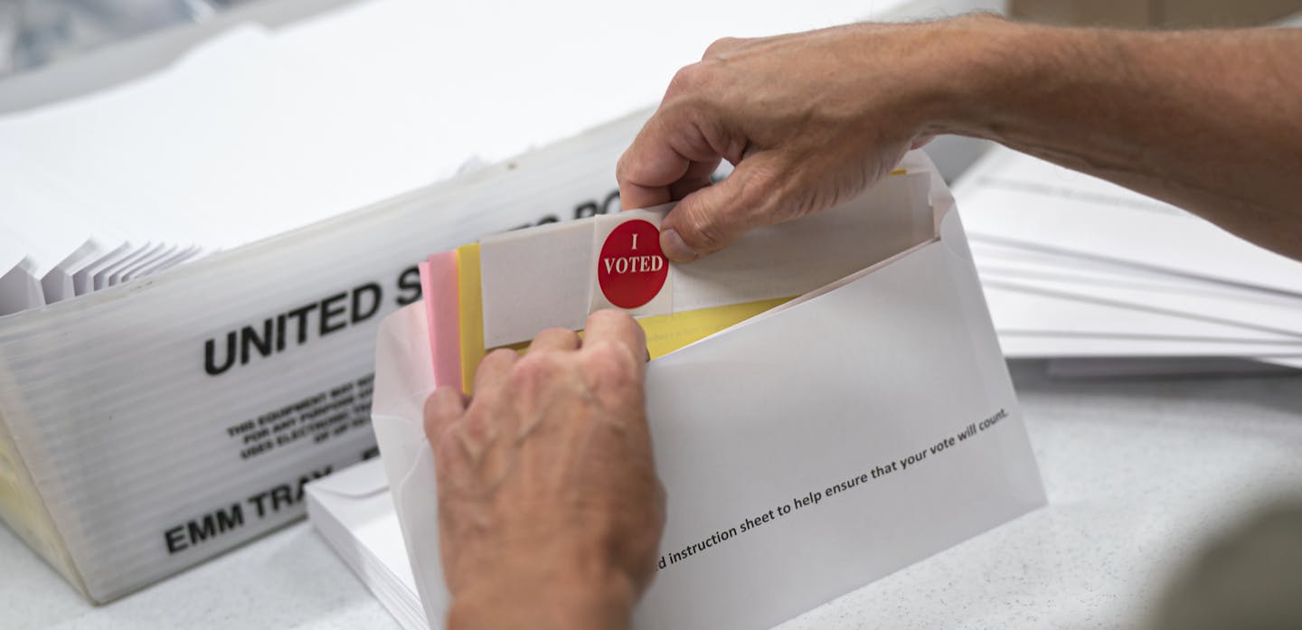 Todd Gallagher prepares mail in ballot envelopes including an I Voted sticker Wednesday, July 29, 2020 in Minneapolis. Absentee ballots are being requested at a record level this year. Nearly 470,000 Minnesotans have requested to vote absentee. That's an amazing 12-times the number requesting mail in voting at this point in 2018. This year's demand obliterates the demand in the 2016 Presidential election, when only 20,000 absentee ballots were requested by July 24. (Glen Stubbe/Star Tribune via