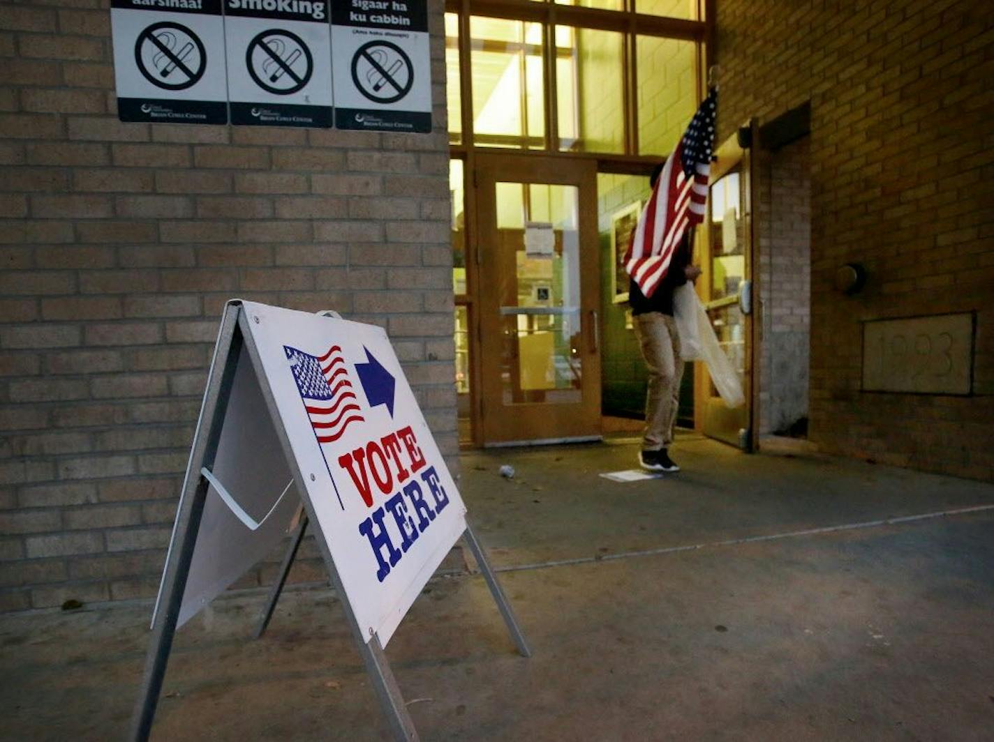 As the polls were about to open for the day at the Brian Coyle Center in Minneapolis on Nov. 7, an election worker walked to place a flag outside the polling place.