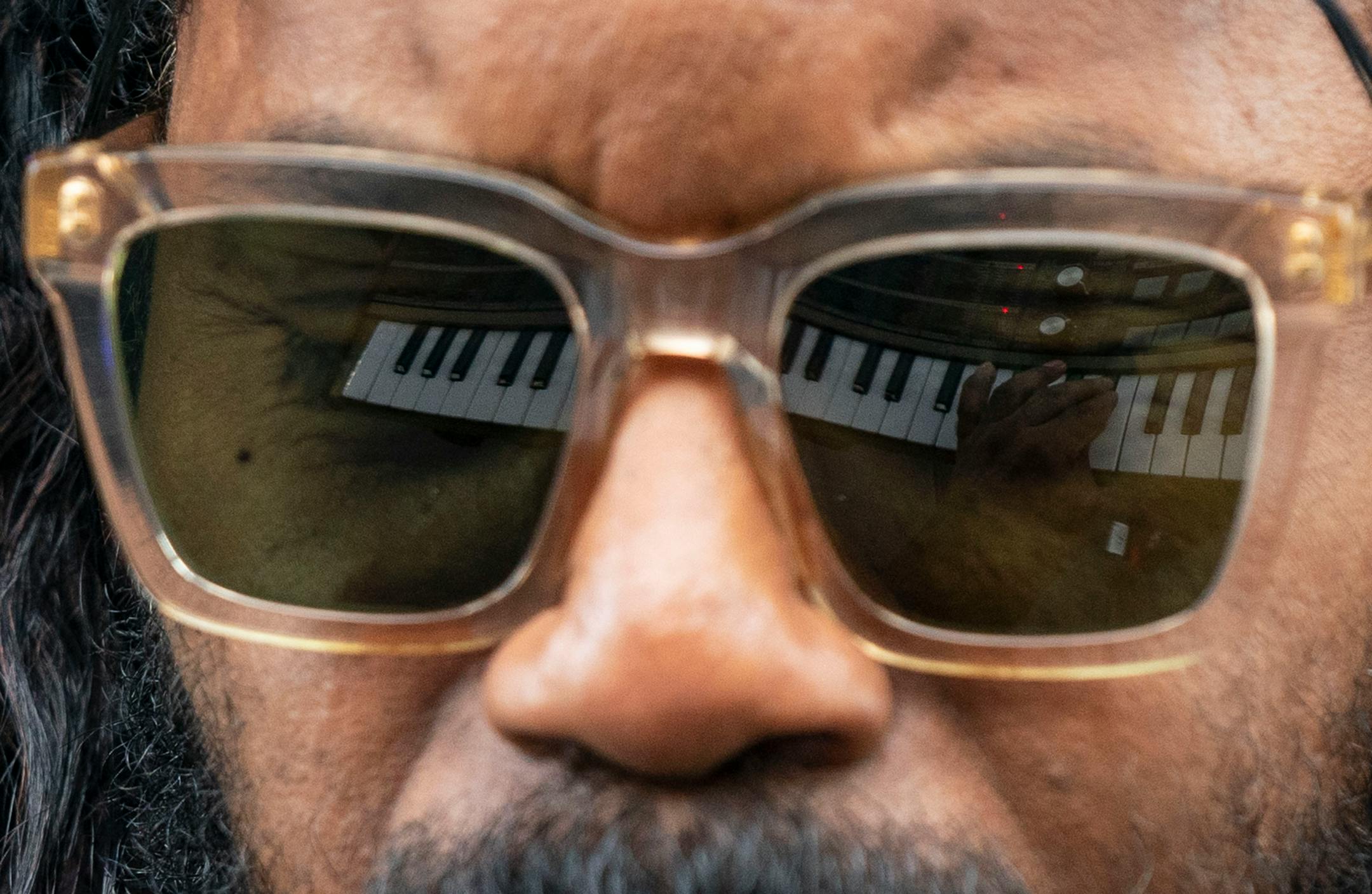 DaM-FunK's keyboard is reflected in his sunglasses as he performs during Rock the Garden.