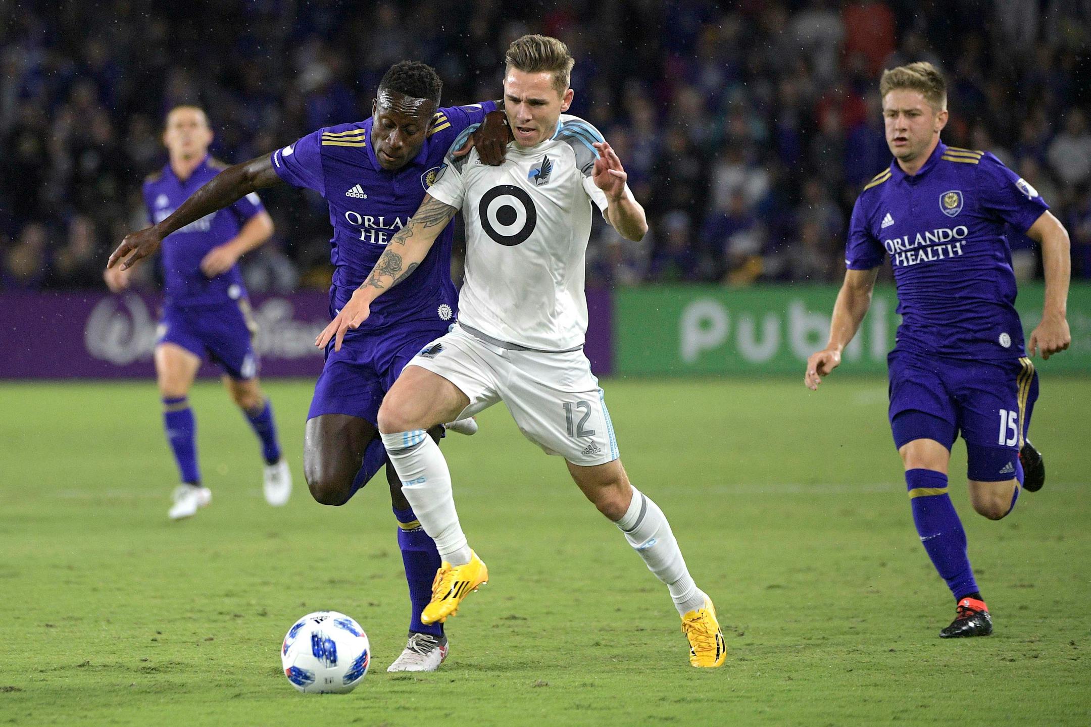Minnesota United midfielder Sam Nicholson (12) battles for the ball with Orlando City midfielder Richie Laryea, left, and midfielder Cameron Lindley (15) during the first half of an MLS soccer match Saturday, March 10, 2018, in Orlando, Fla. Minnesota won 2-1. (Phelan M. Ebenhack for the Star-Tribune) ORG XMIT: OTKMINN121
