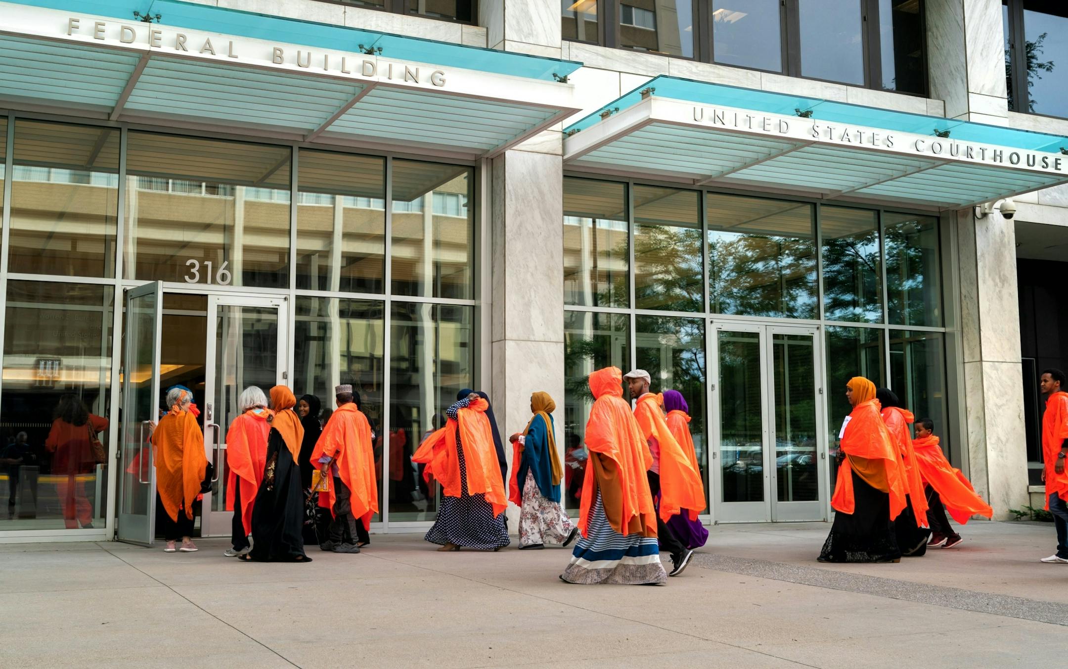 Protesters wore orange ponchos in solidarity with the three men being who were convicted in plotting to join ISIS. The men are appearing before a three-judge federal appeals court panel Thursday morning. Protesters were not allowed to enter the courthouse until the orange ponchos and signs bearing the names of the convicted men were removed.